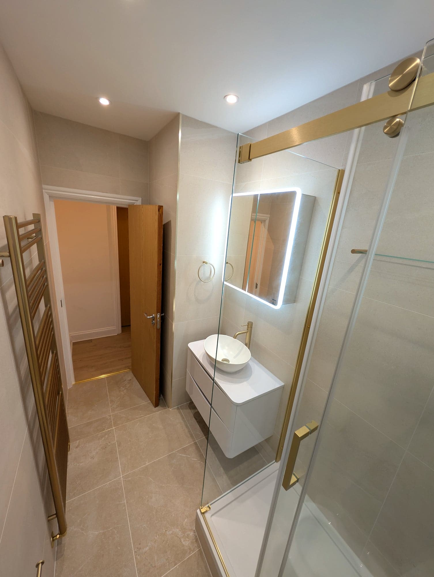 Bathroom from the doorway with the backlit mirror and glass shower screen, Nine Elms SW8