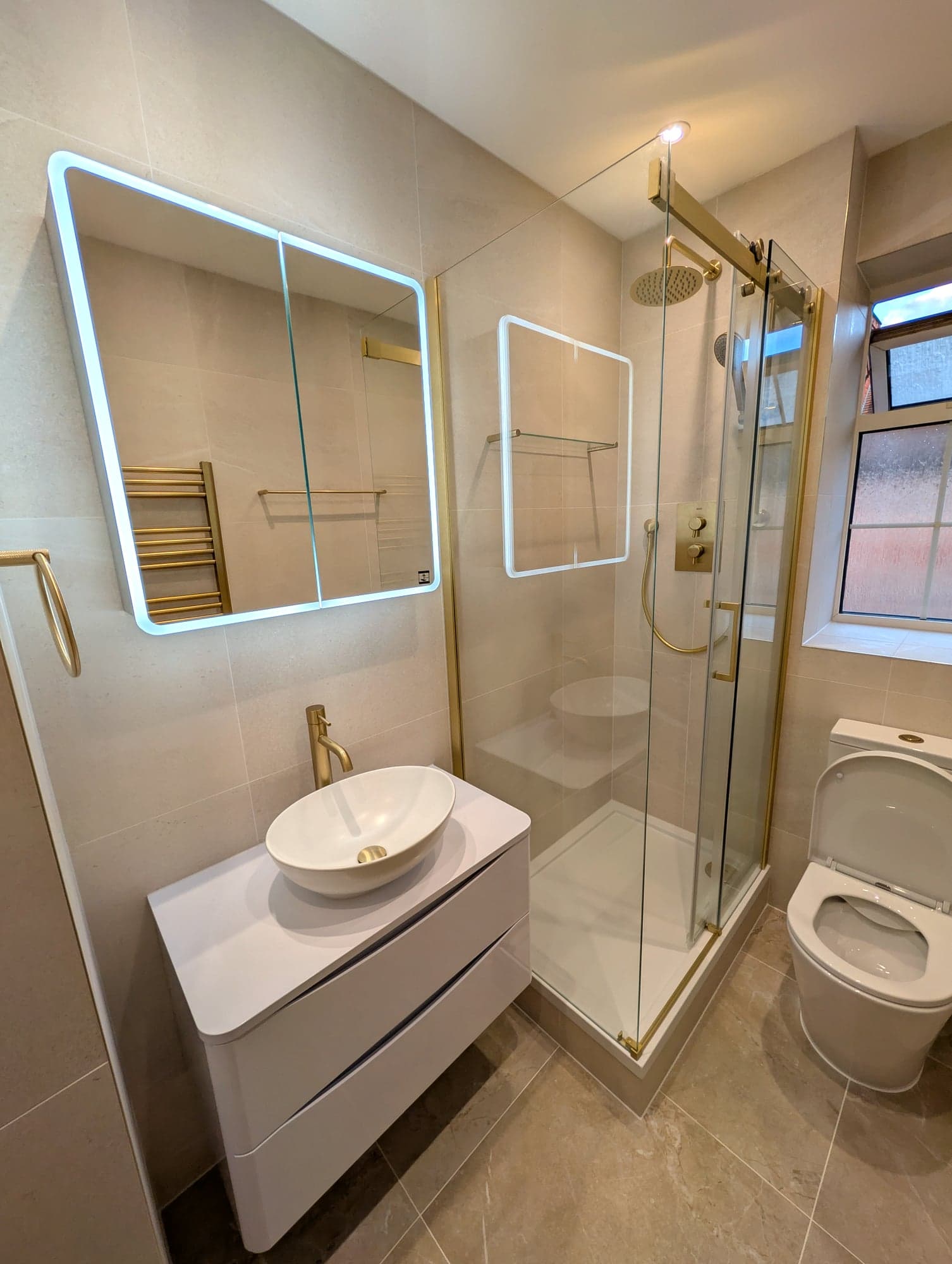 Countertop basin and backlit mirror with the shower and WC behind, Nine Elms SW8