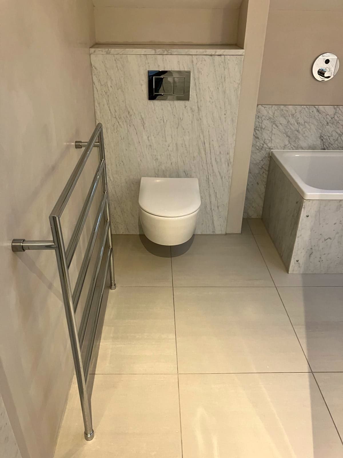 Wall-hung WC, marble-clad bath panel and chrome towel rail, South Kensington SW7
