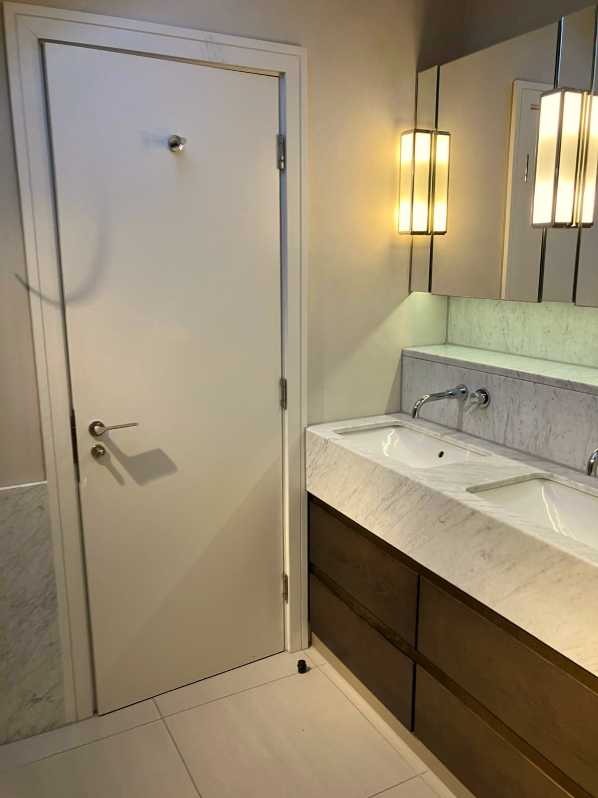 Walnut double vanity and marble top beside the panelled door, South Kensington SW7