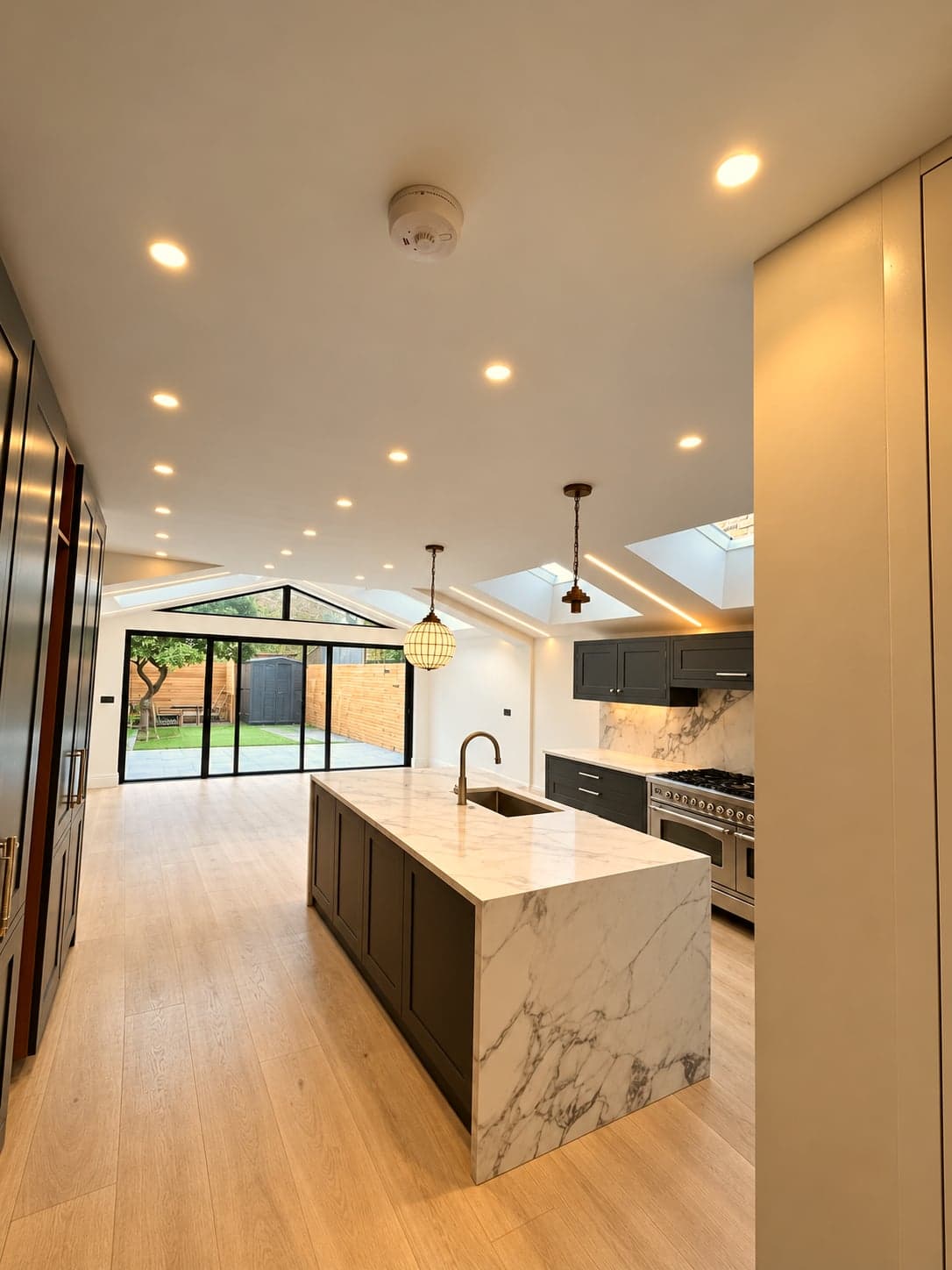 Marble island and kitchen run with the lantern rooflight and bi-folds beyond, St Albans AL1