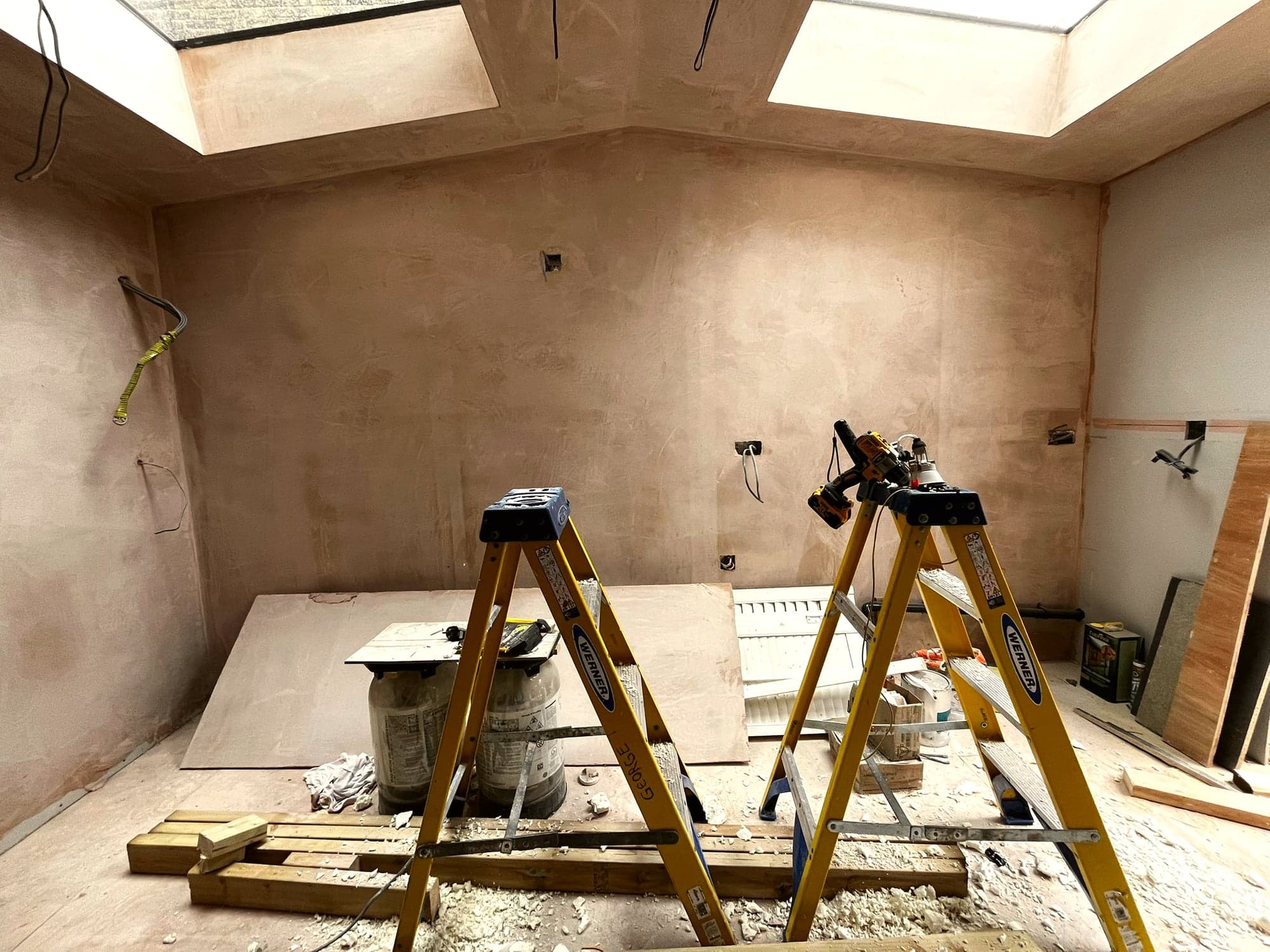 Strip-out stage: original room back to bare plaster with trestles and rubble, St Albans AL1