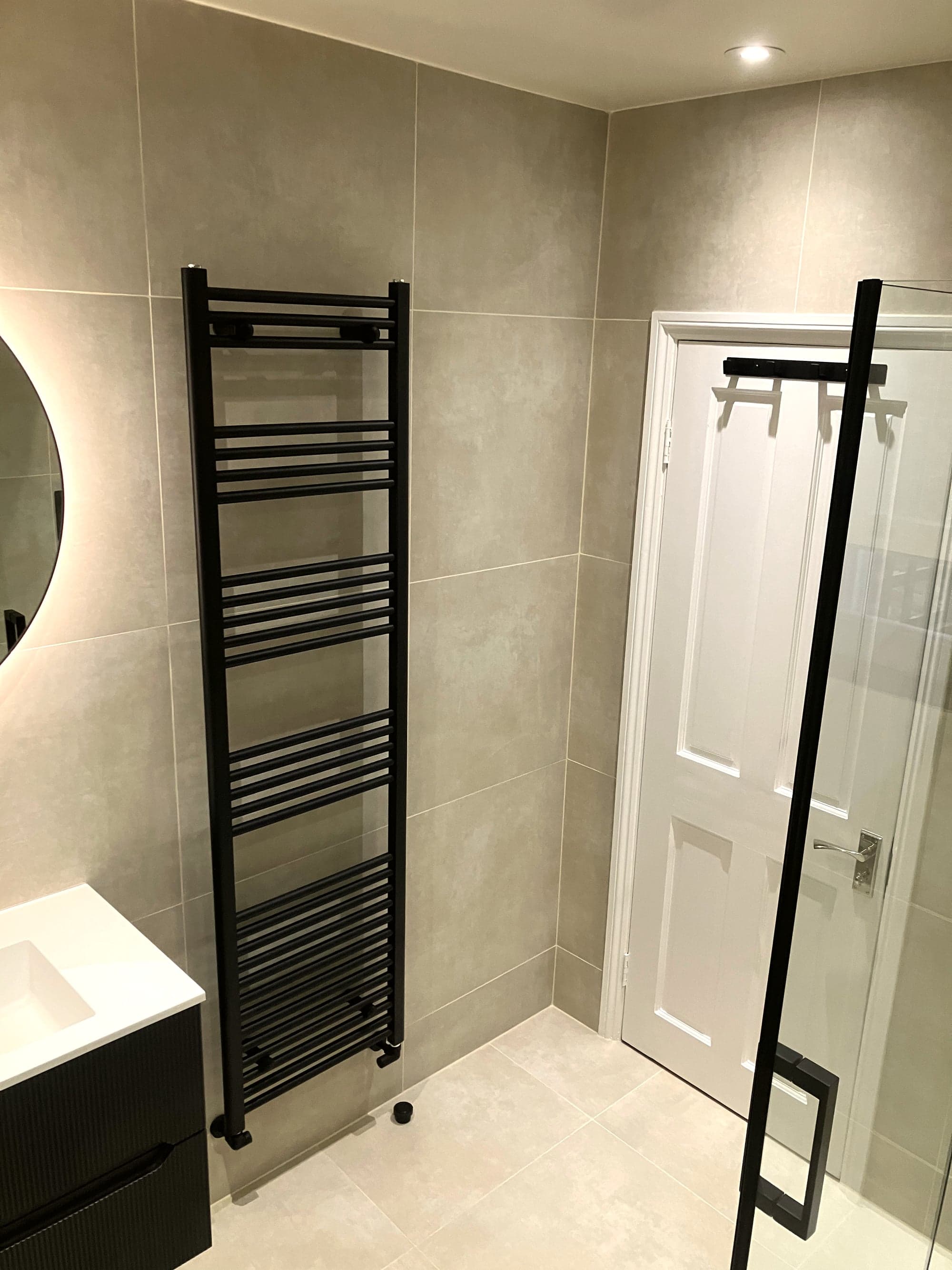 Black towel rail beside the panelled door, vanity to the left, Clapham Common SW4