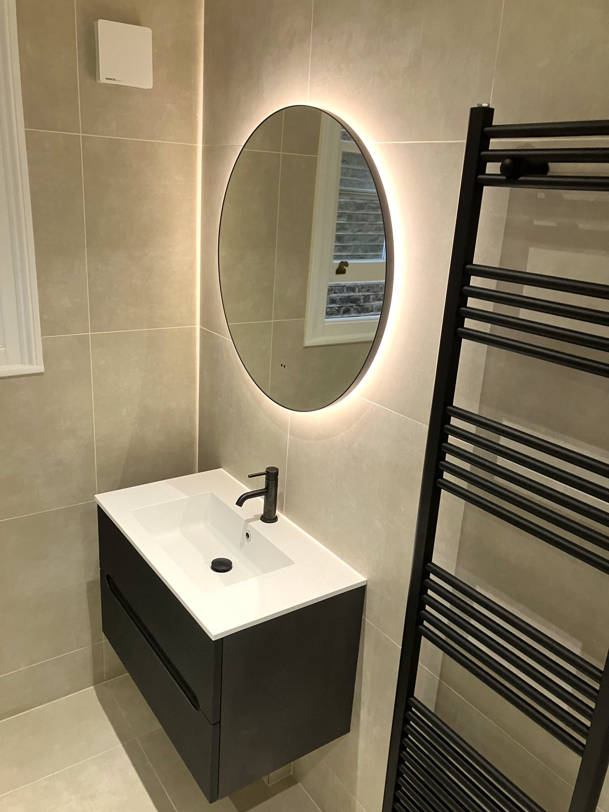 Wall-hung vanity, round backlit mirror and towel rail in one view, Clapham Common SW4