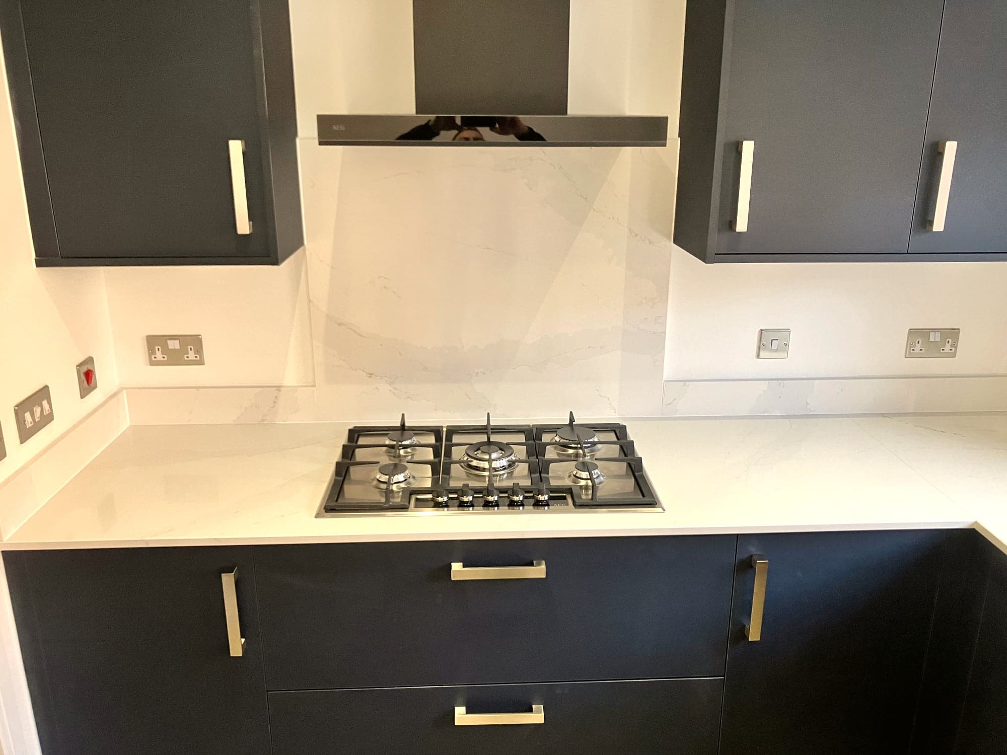 Five-burner gas hob and marble-effect splashback below the extractor, Hampstead NW3