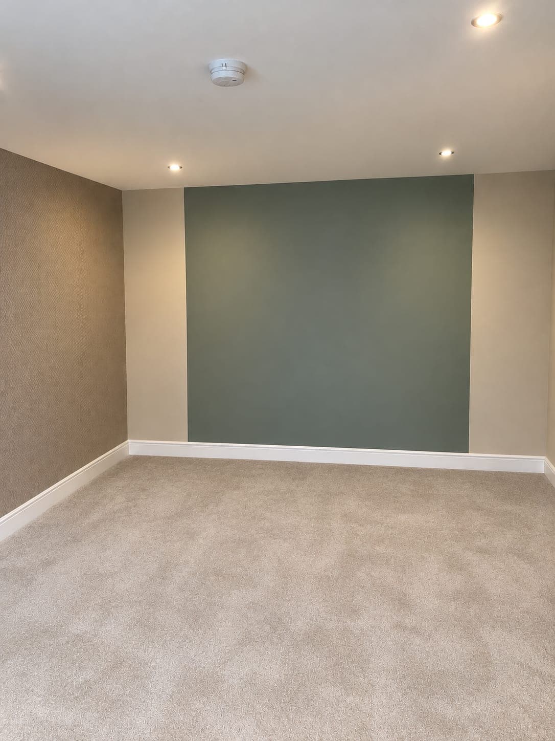 Green feature wall cut in cleanly against the papered side walls, London Colney AL2