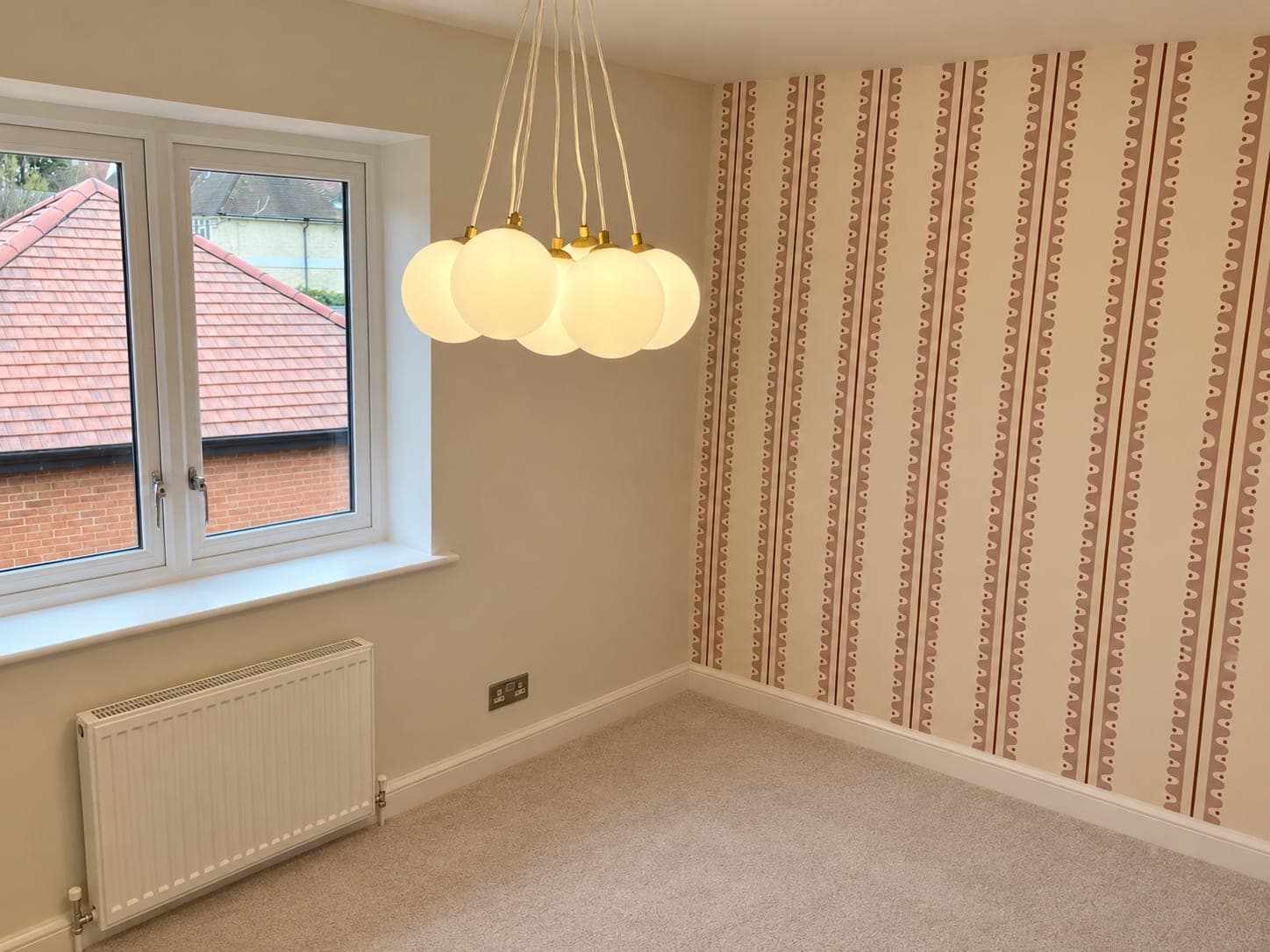 Bedroom papered in a striped wallcovering with white woodwork, London