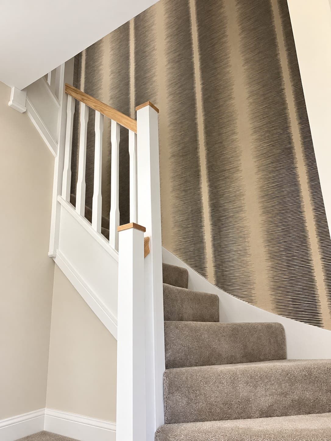 Staircase papered full height in a grasscloth-effect wallcovering, London