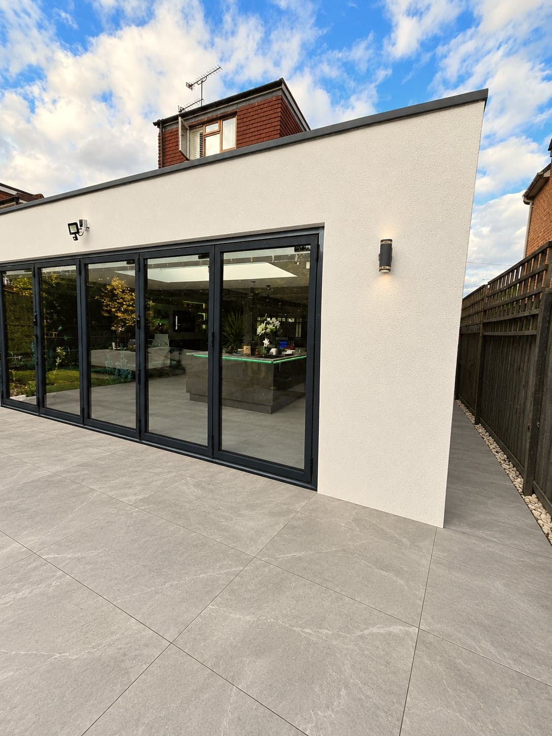 Rendered rear extension from the garden corner, sliding doors open onto the terrace, High Barnet EN5