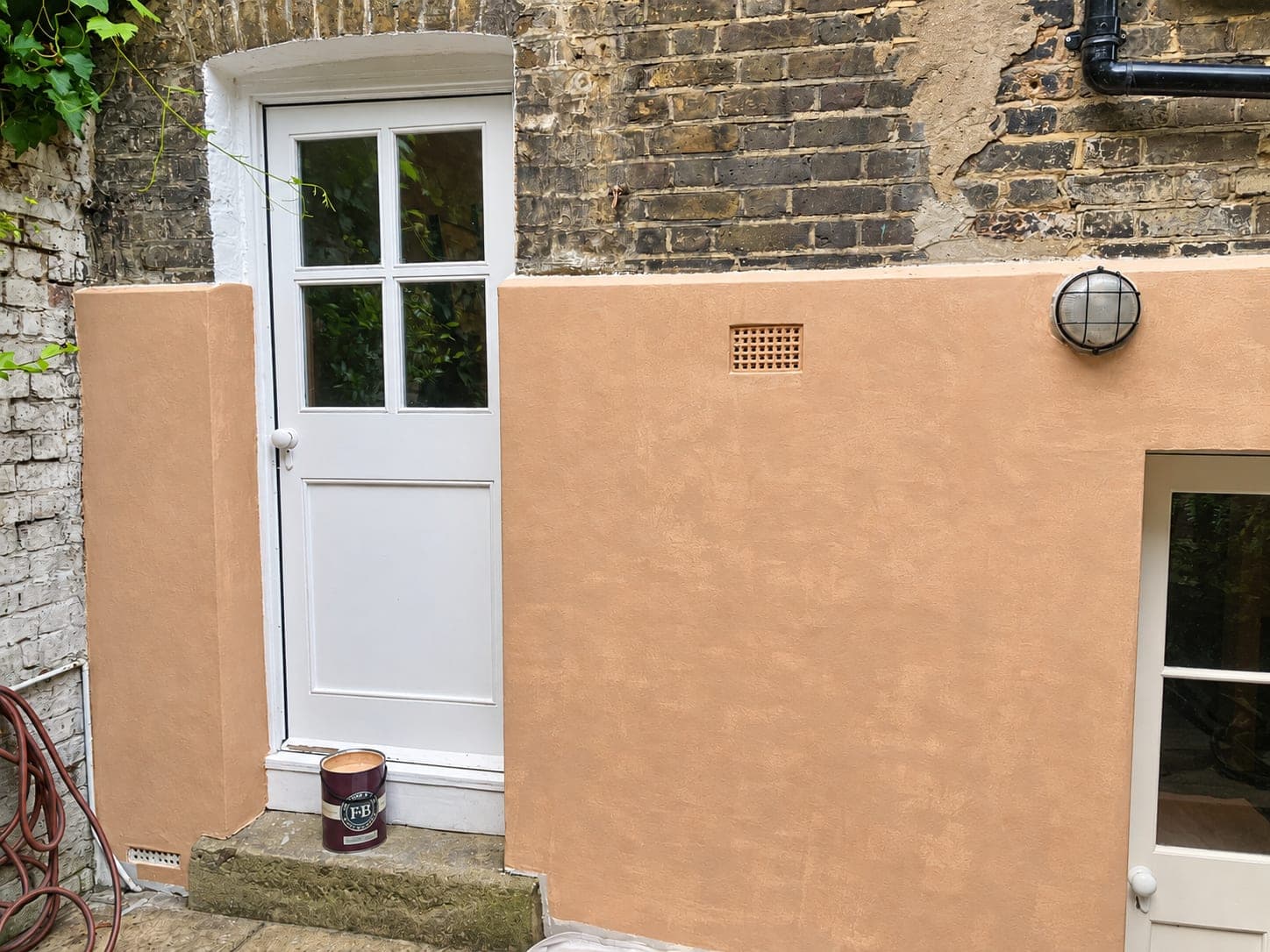 Render taken up to the door reveal with a clean edge against the brick, Hammersmith W6