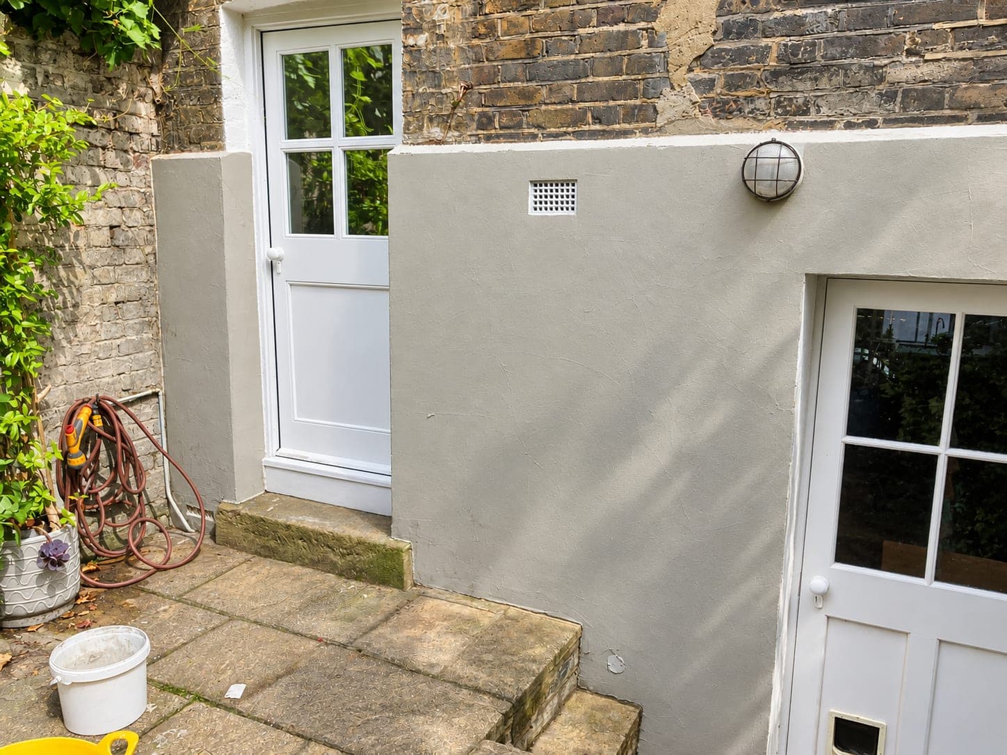 Render base coat around the door opening and vent, Hammersmith W6