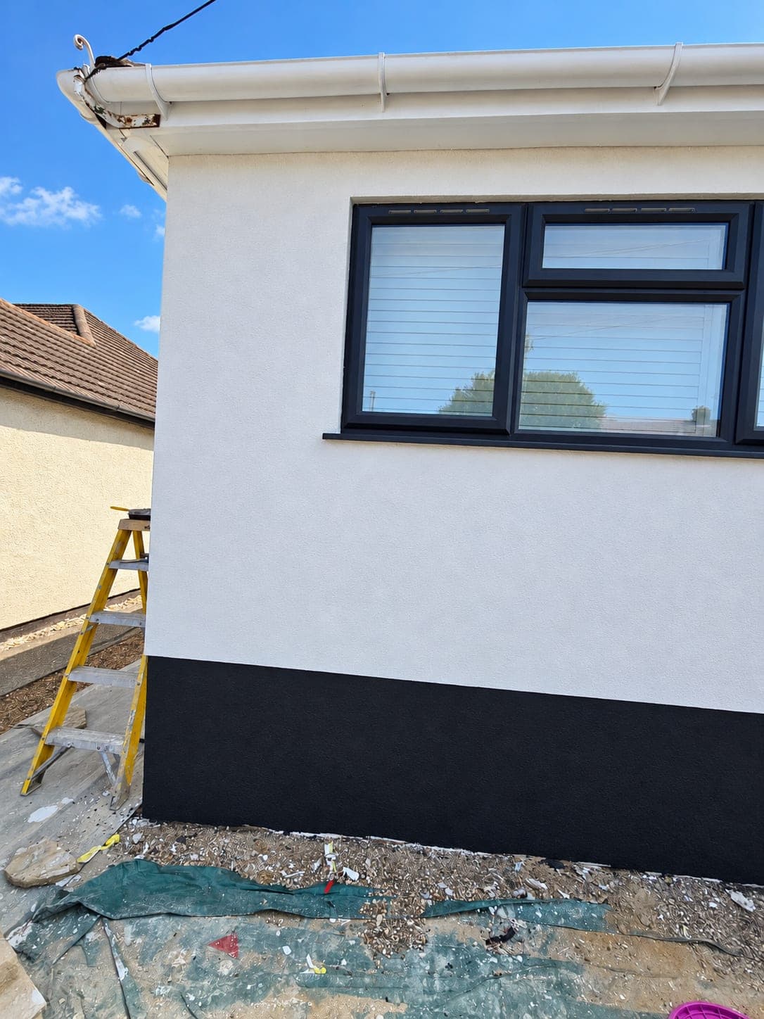 Corner of the rendered elevation showing the clean edge between white and plinth, Bricket Wood AL2