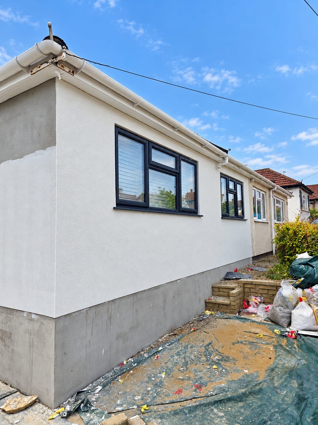 Front corner of the bungalow finished in white render, Bricket Wood AL2