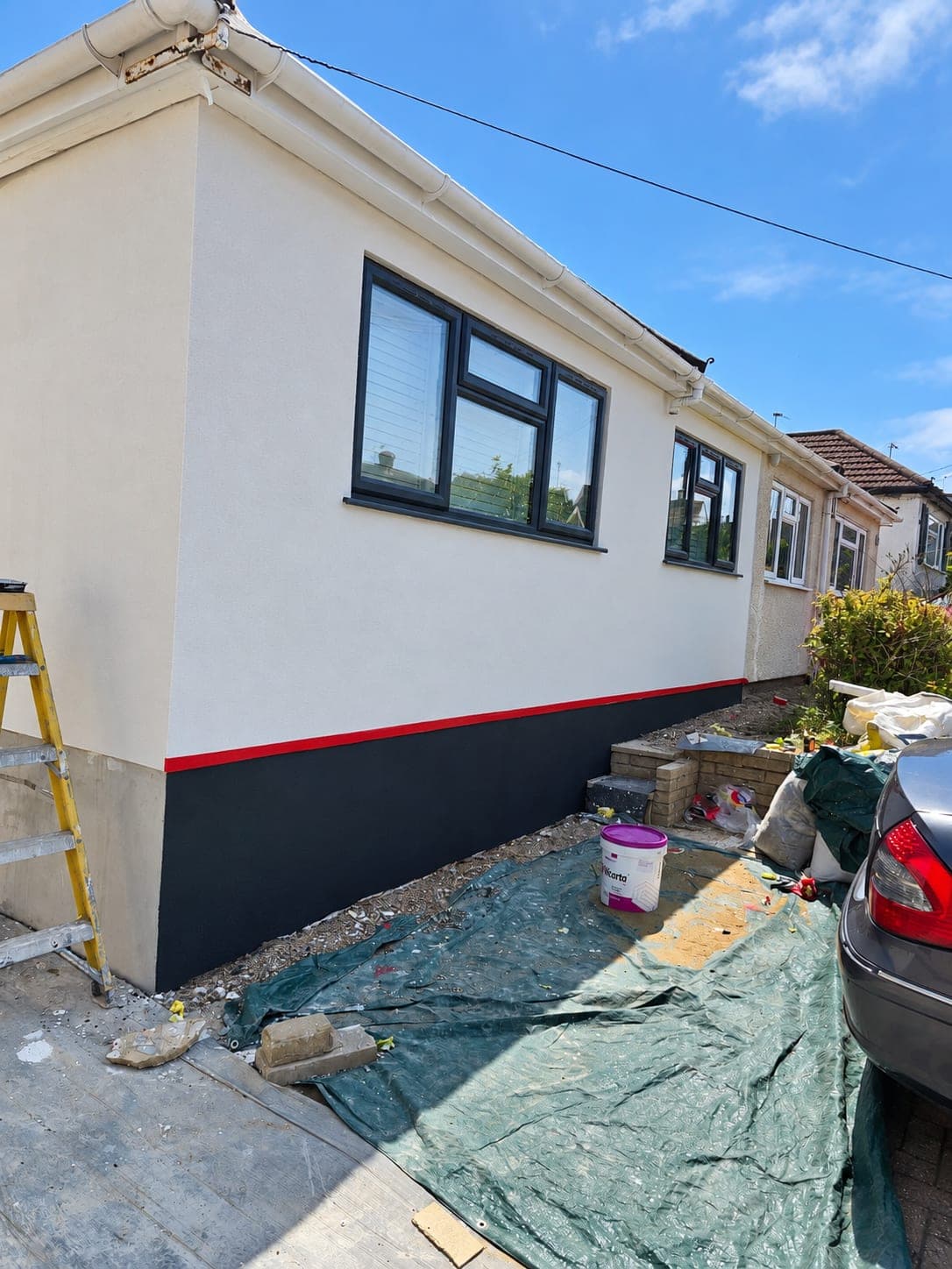 The same corner finished in white render with a red trim line, London