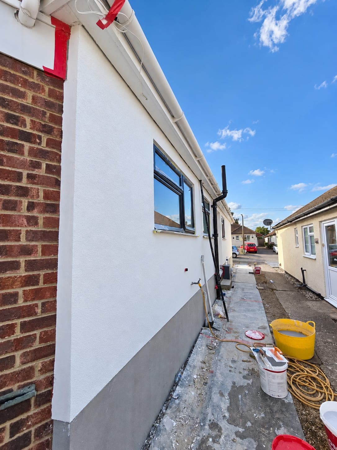 White render taken up against the retained brickwork, London