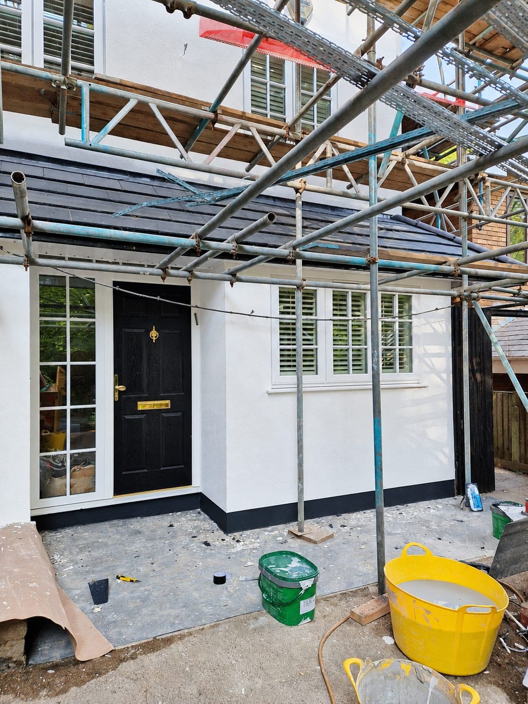Front entrance with new render, dark plinth and black door, Enfield EN3