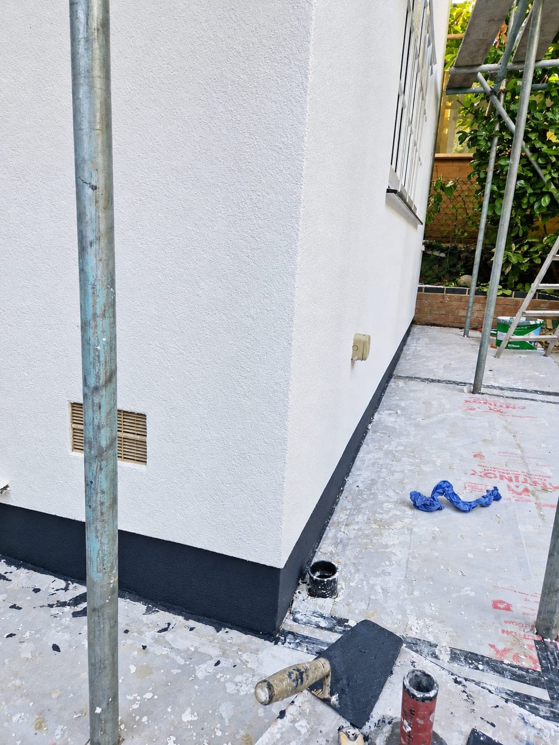 Corner detail where the white render meets the dark plinth, Enfield EN3