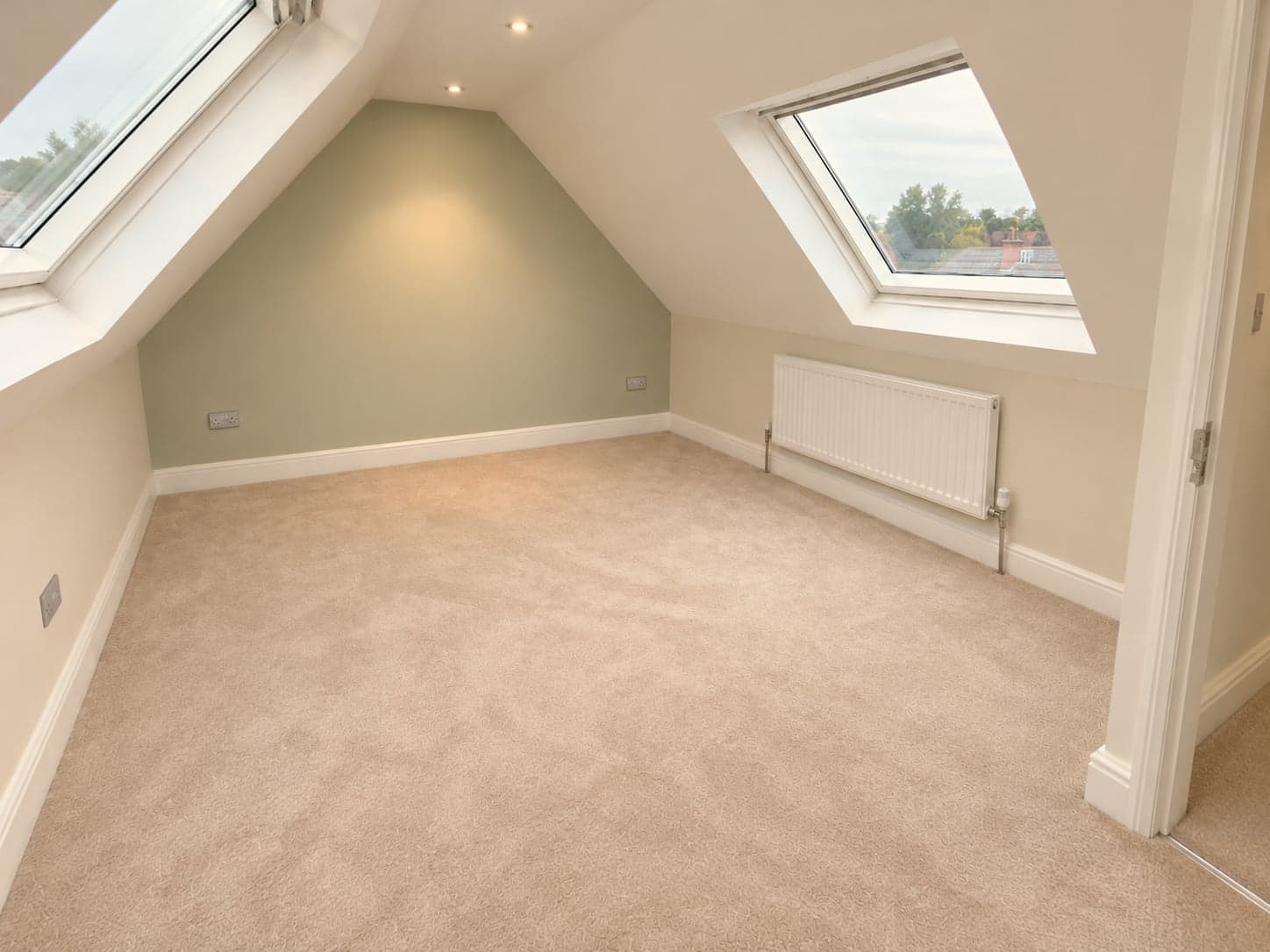 Loft room with roof windows set into the sloping ceiling and radiator below, Barnet EN5