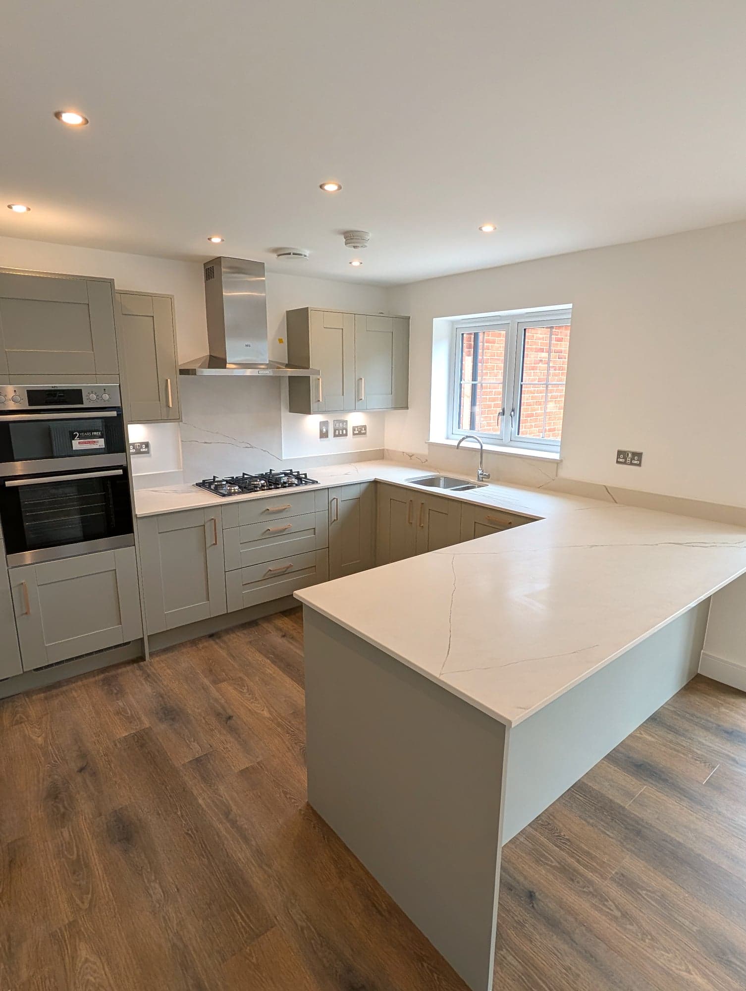 Hob and extractor with the sink run under the window to the right, Chiswick W4