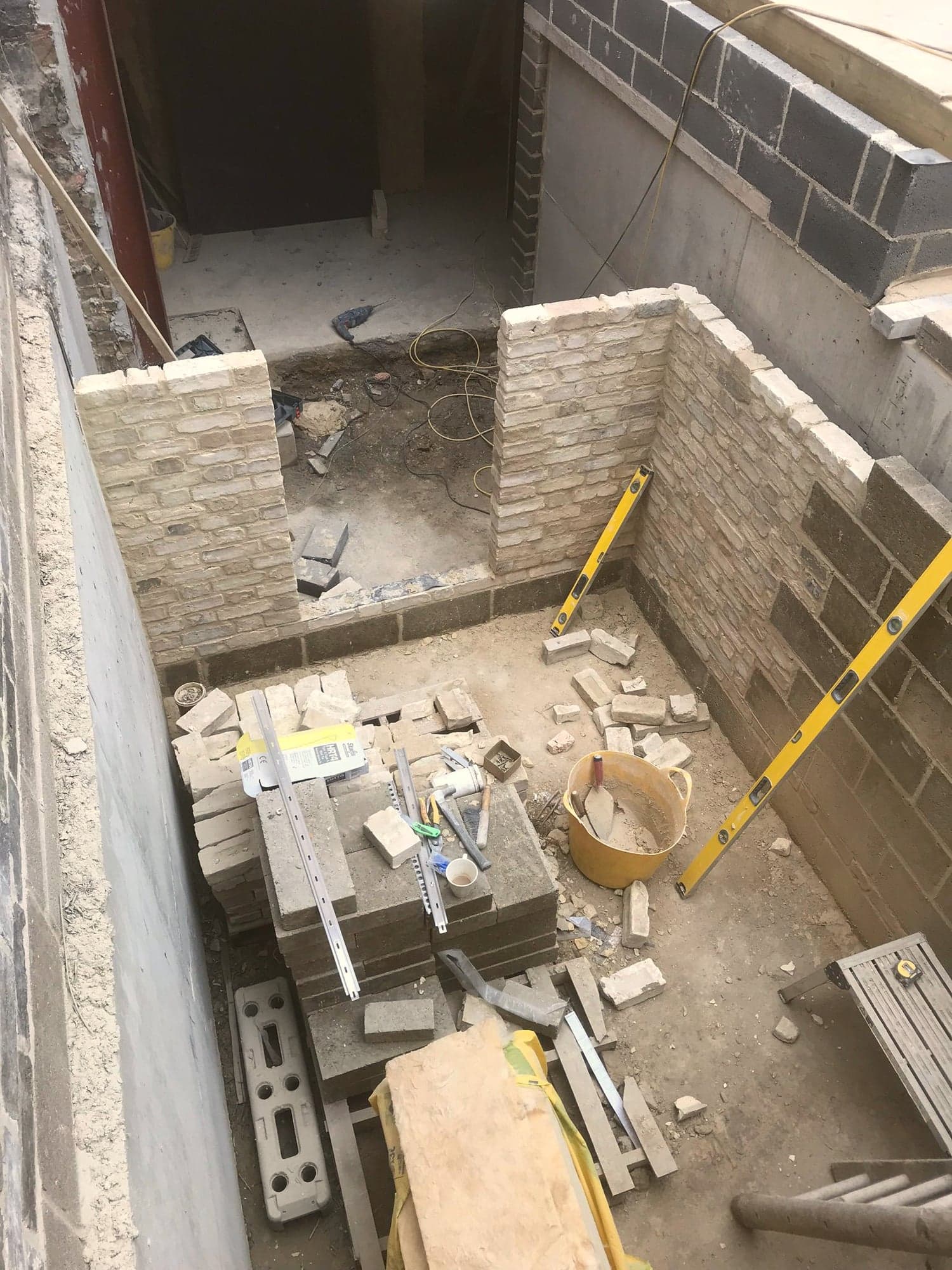 Sunken courtyard dug out and the retaining stonework being built, Kensington W8