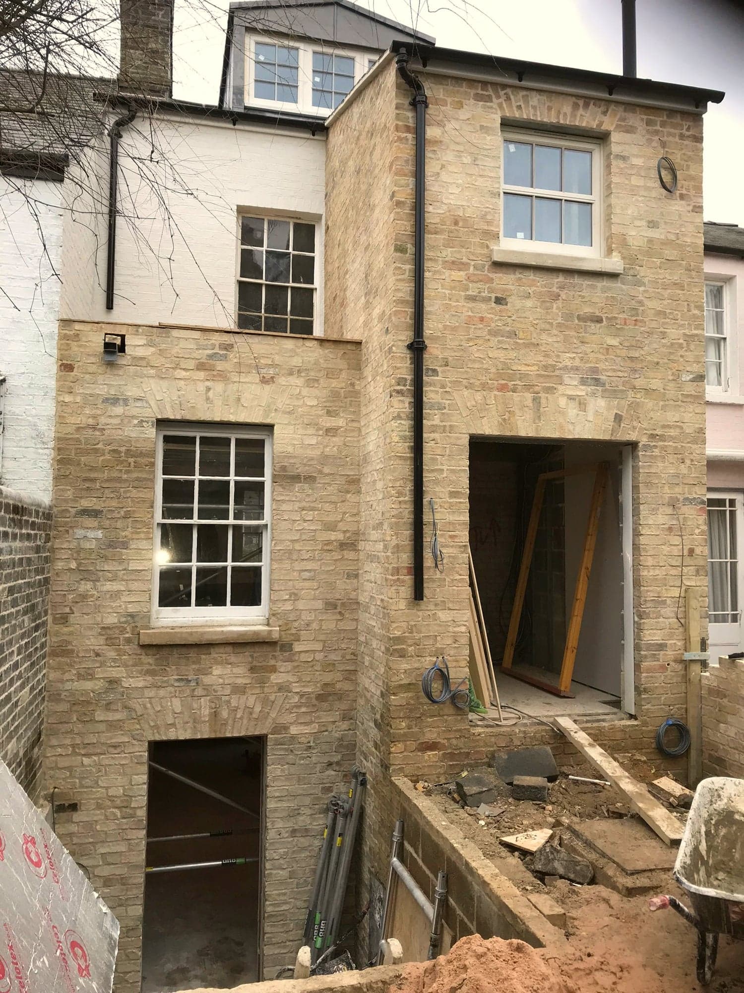 Stone extension shell with the lower opening propped and the courtyard still open ground, Kensington W8