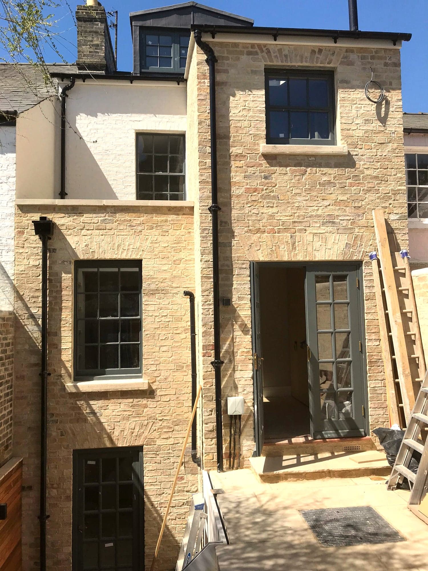 Stone extension nearing completion, frames in and paving being laid, Kensington W8