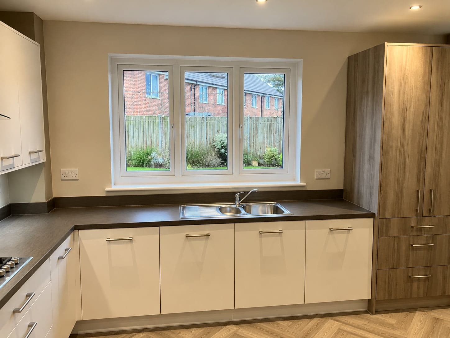 Inset sink and dark worktop below the window between the two tall units, St Albans AL1