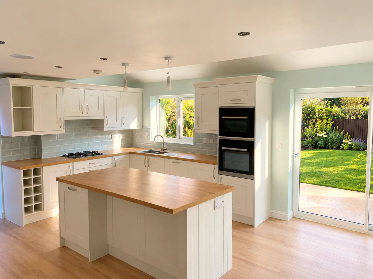 Kitchen from the far end: island, integrated double oven and the new rear doors, Borehamwood WD6