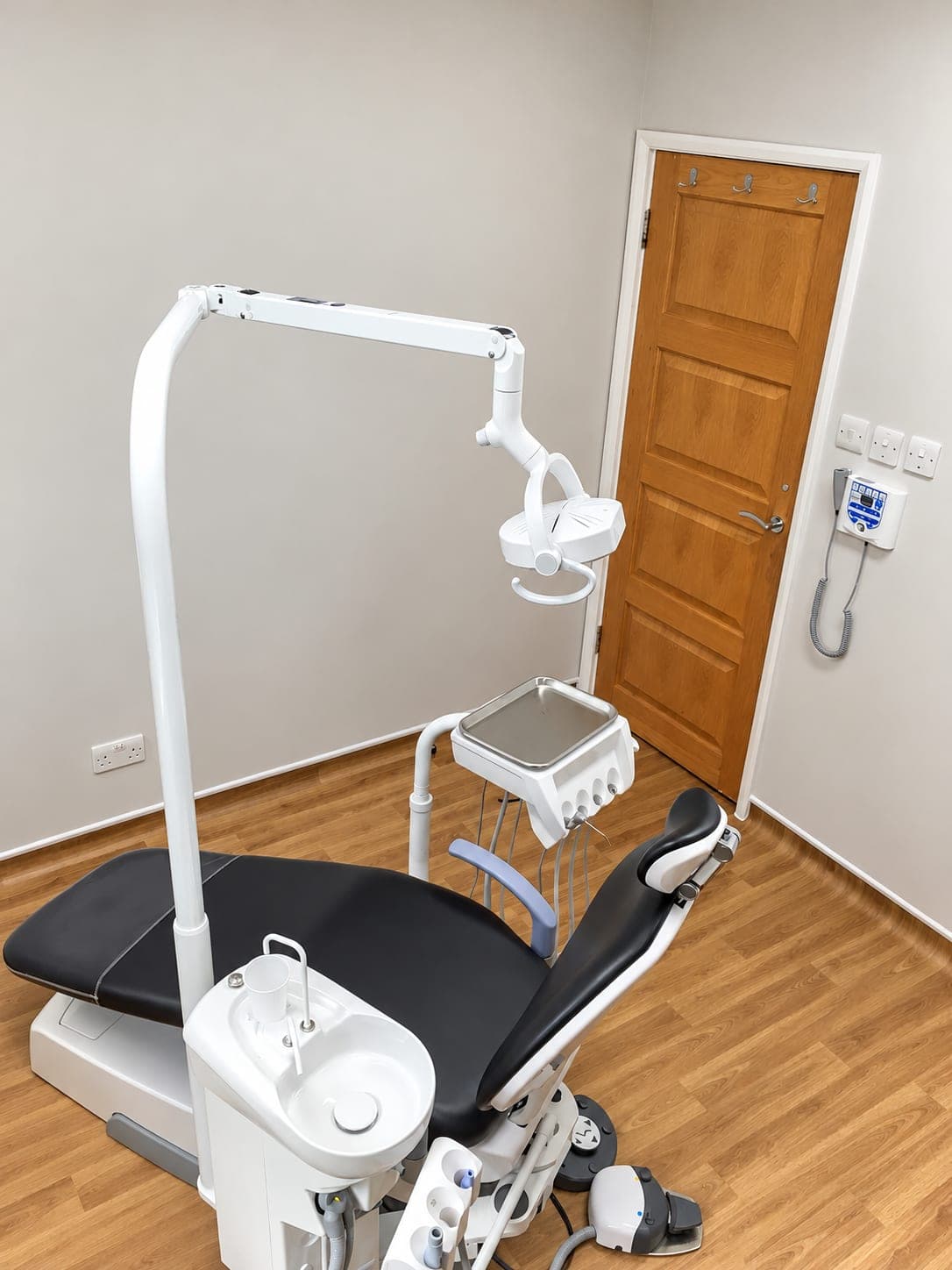 Chair and delivery unit beside the panelled door and wall-mounted X-ray controls, Winchmore Hill N21