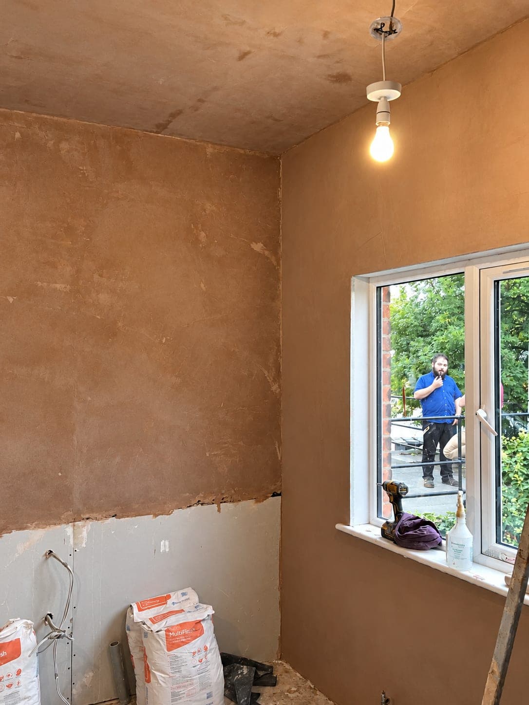 Plastering under way with the walls made good around the window, Winchmore Hill N21