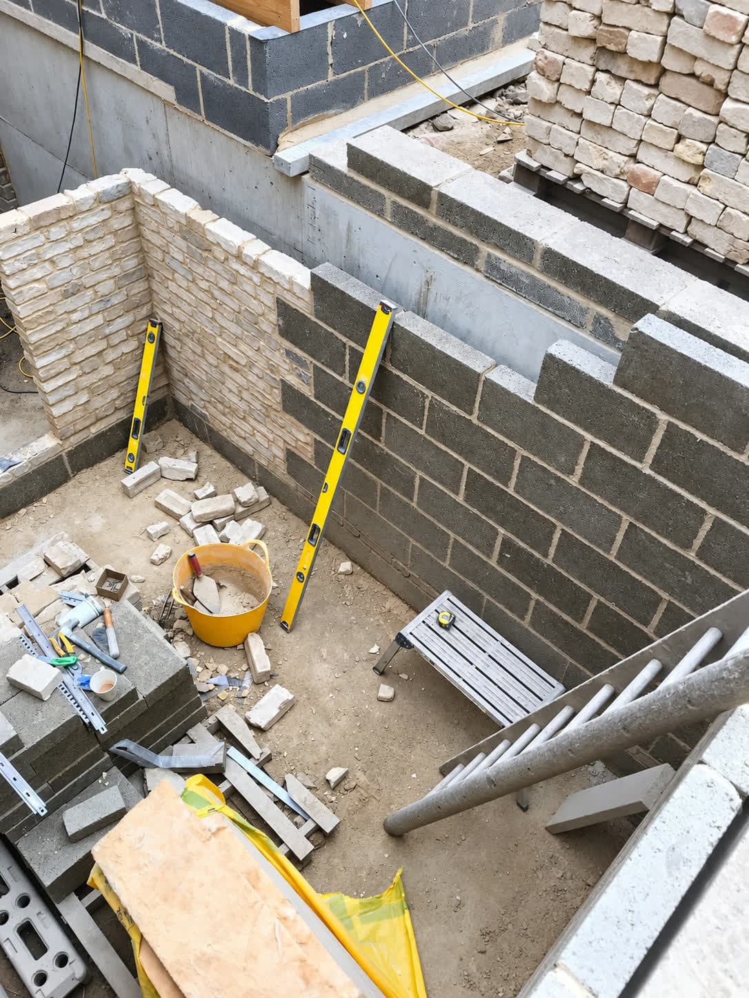Stock brick outer leaf laid course by course with levels on the wall, London