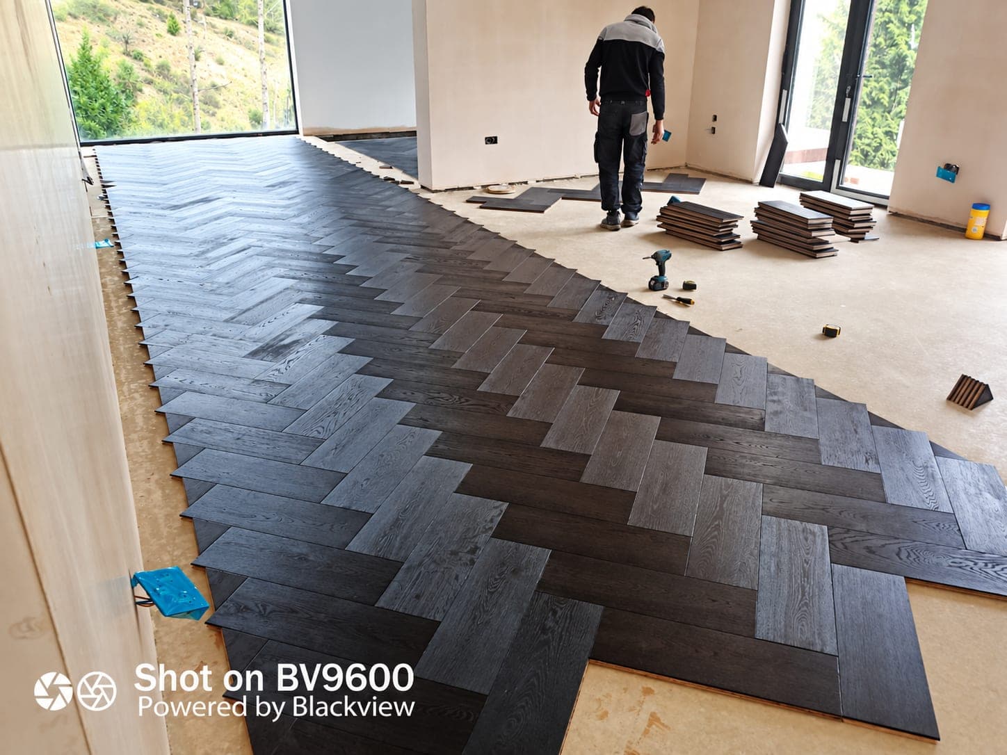 Carpenter laying a dark herringbone wood floor, London