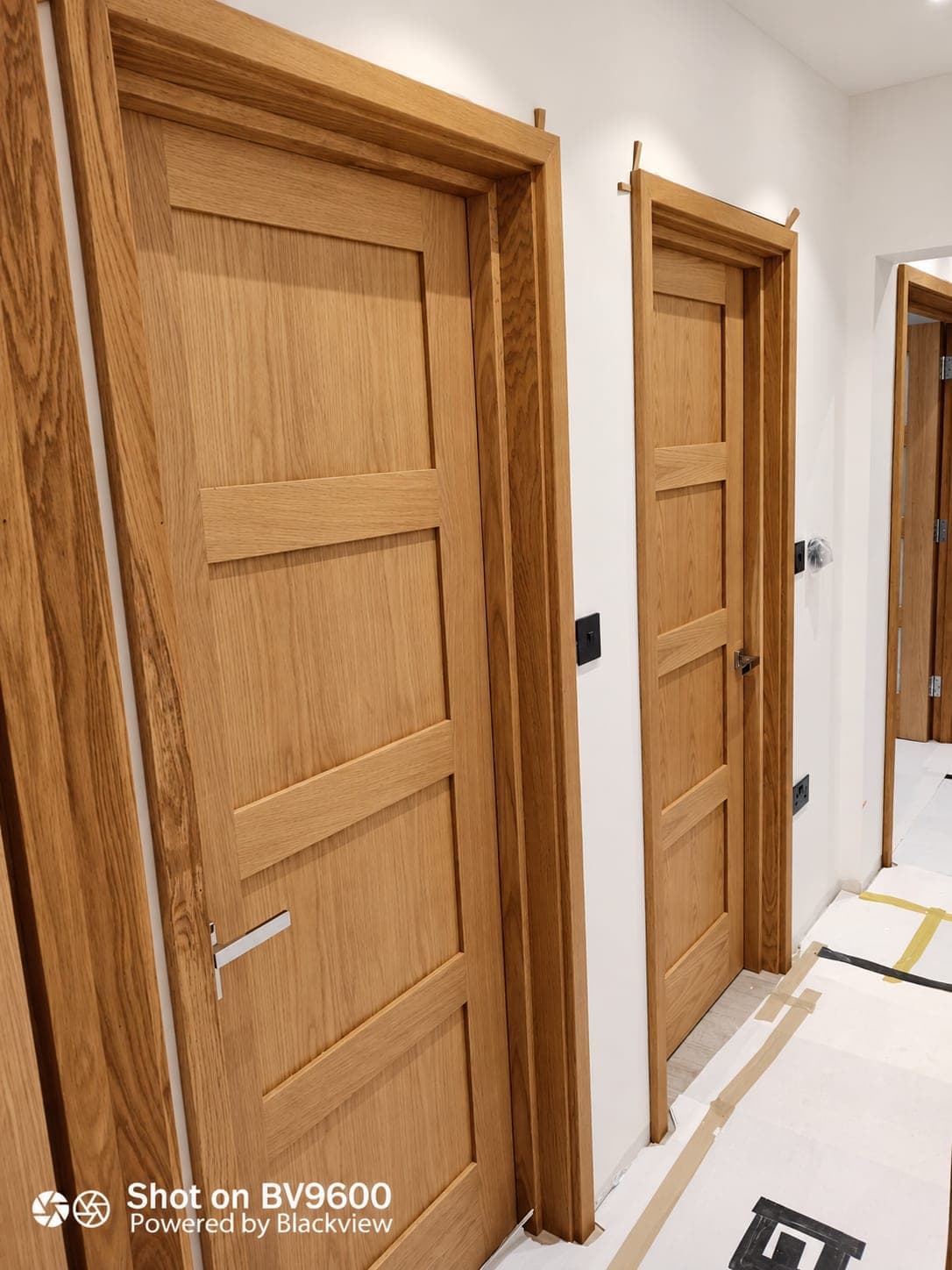 Panelled oak doors and frames hung along a hallway, London