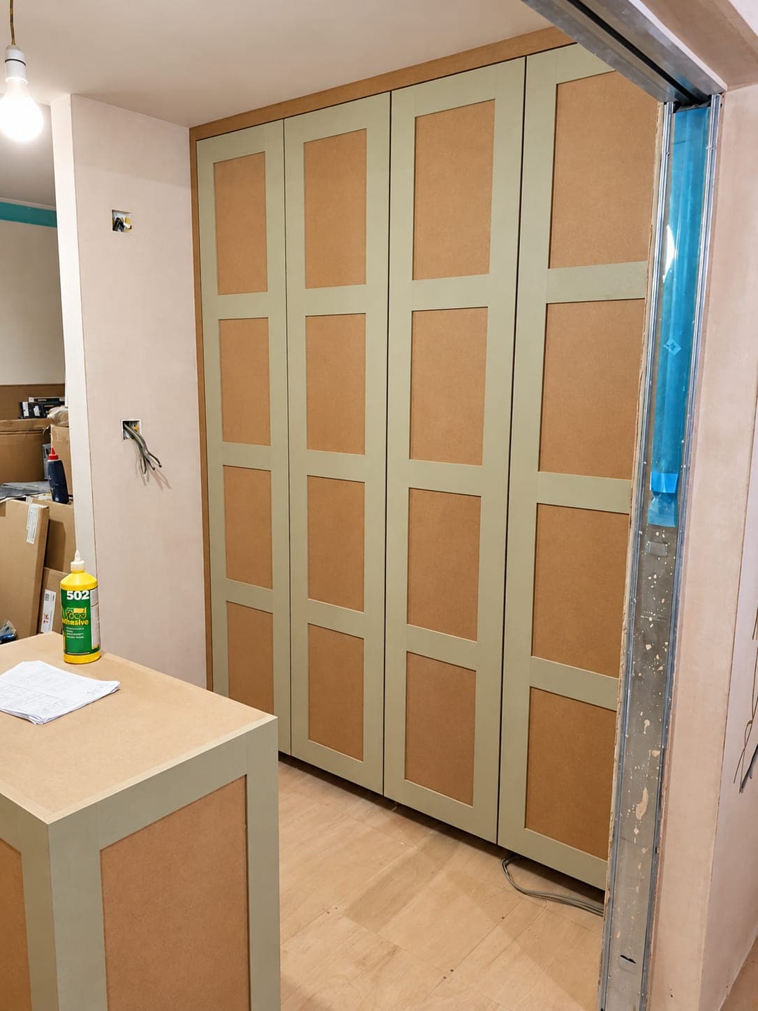 Fitted wardrobe with panelled doors in a sage finish, London