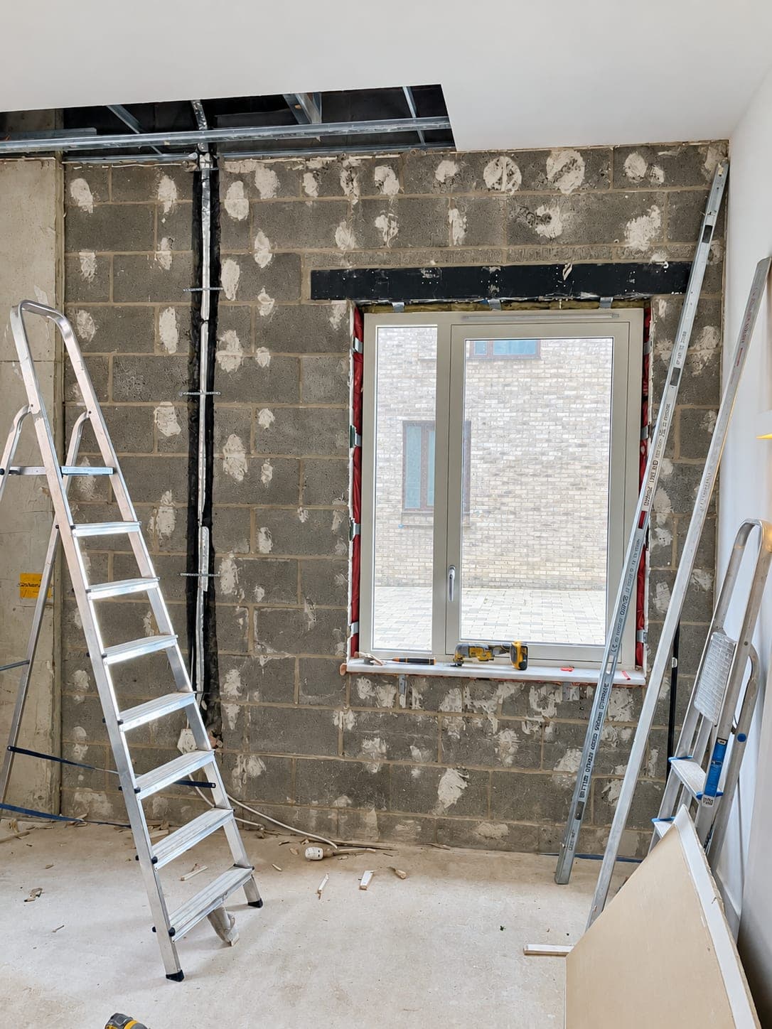 Blockwork prepared with adhesive dabs for insulated plasterboard, London