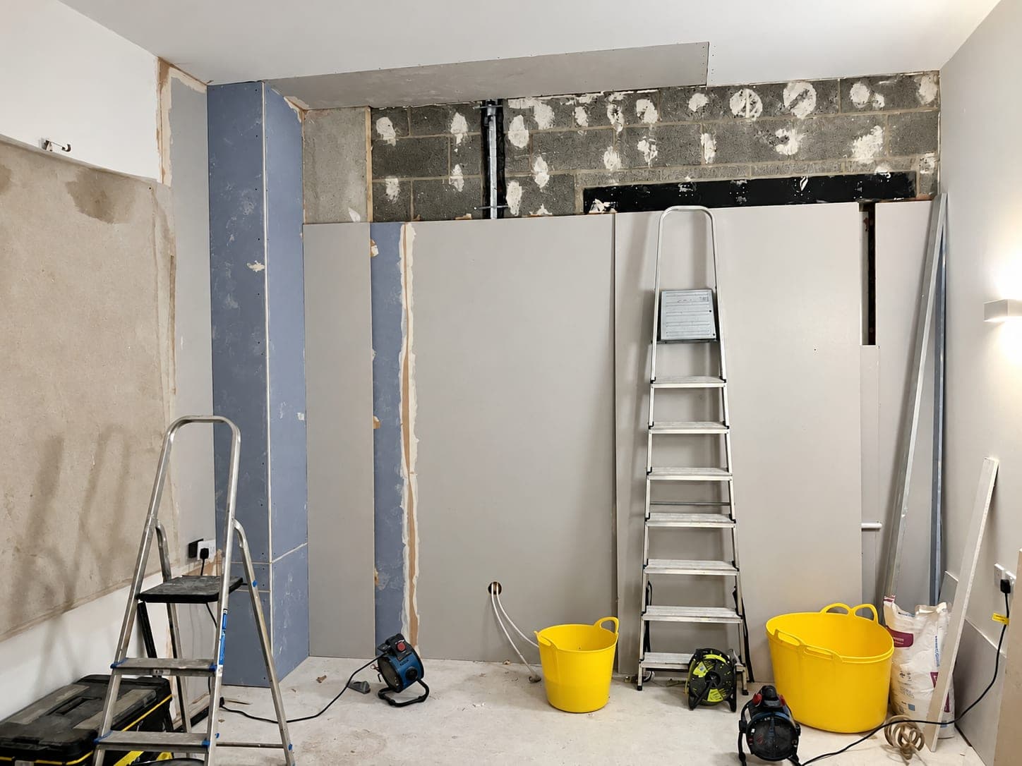 Insulated plasterboard fixed part way up a blockwork wall, London