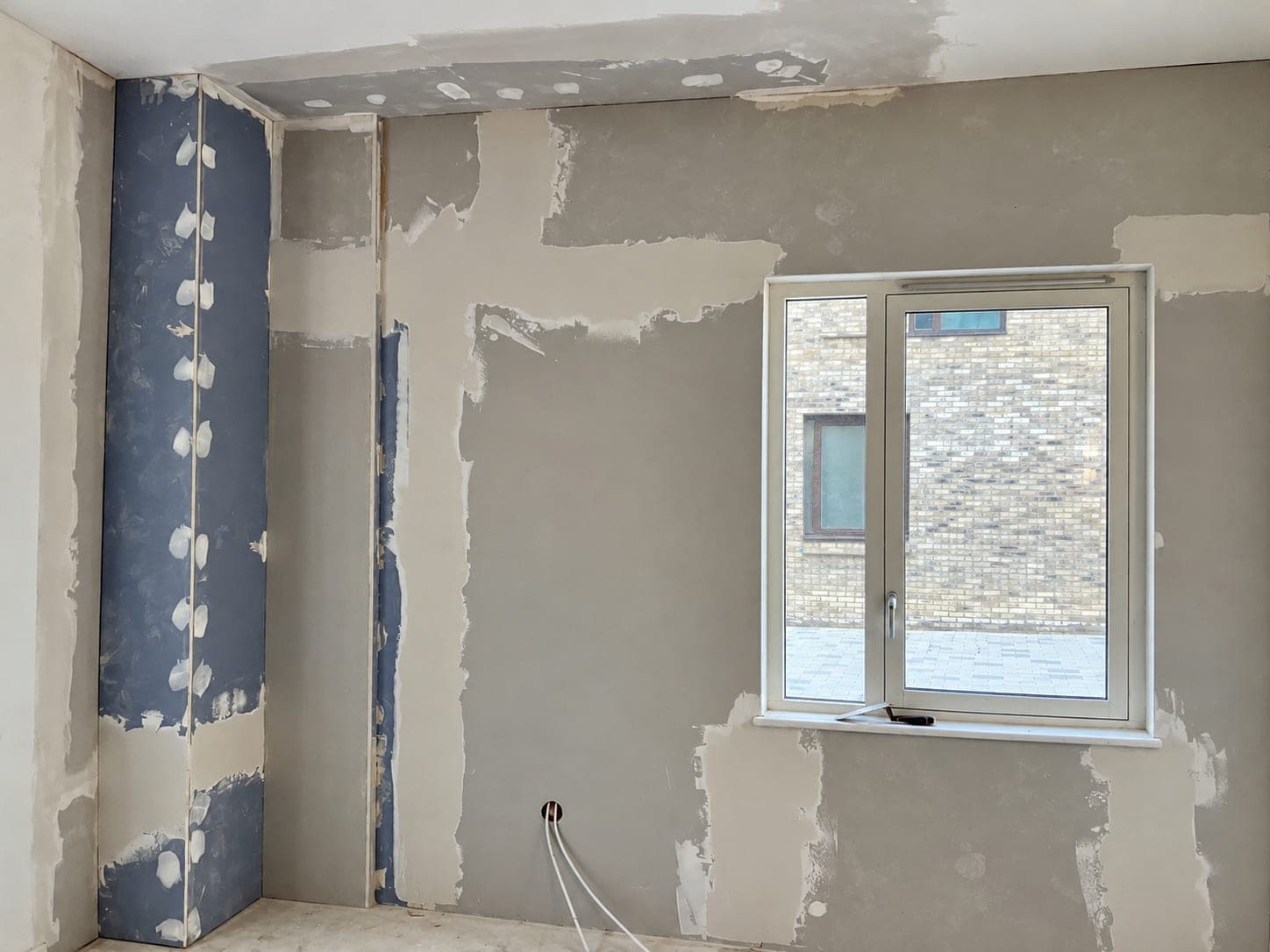 Wall patched and prepared ahead of the new lining, London