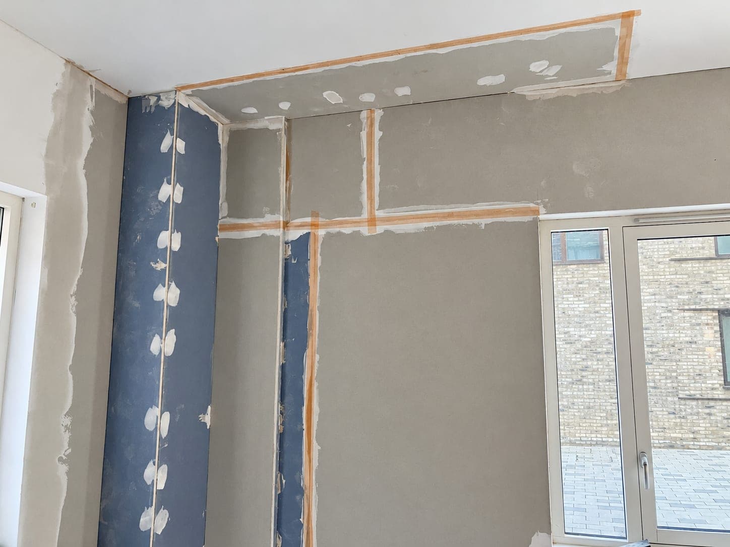 Scrim tape and filler applied to plasterboard joints, London