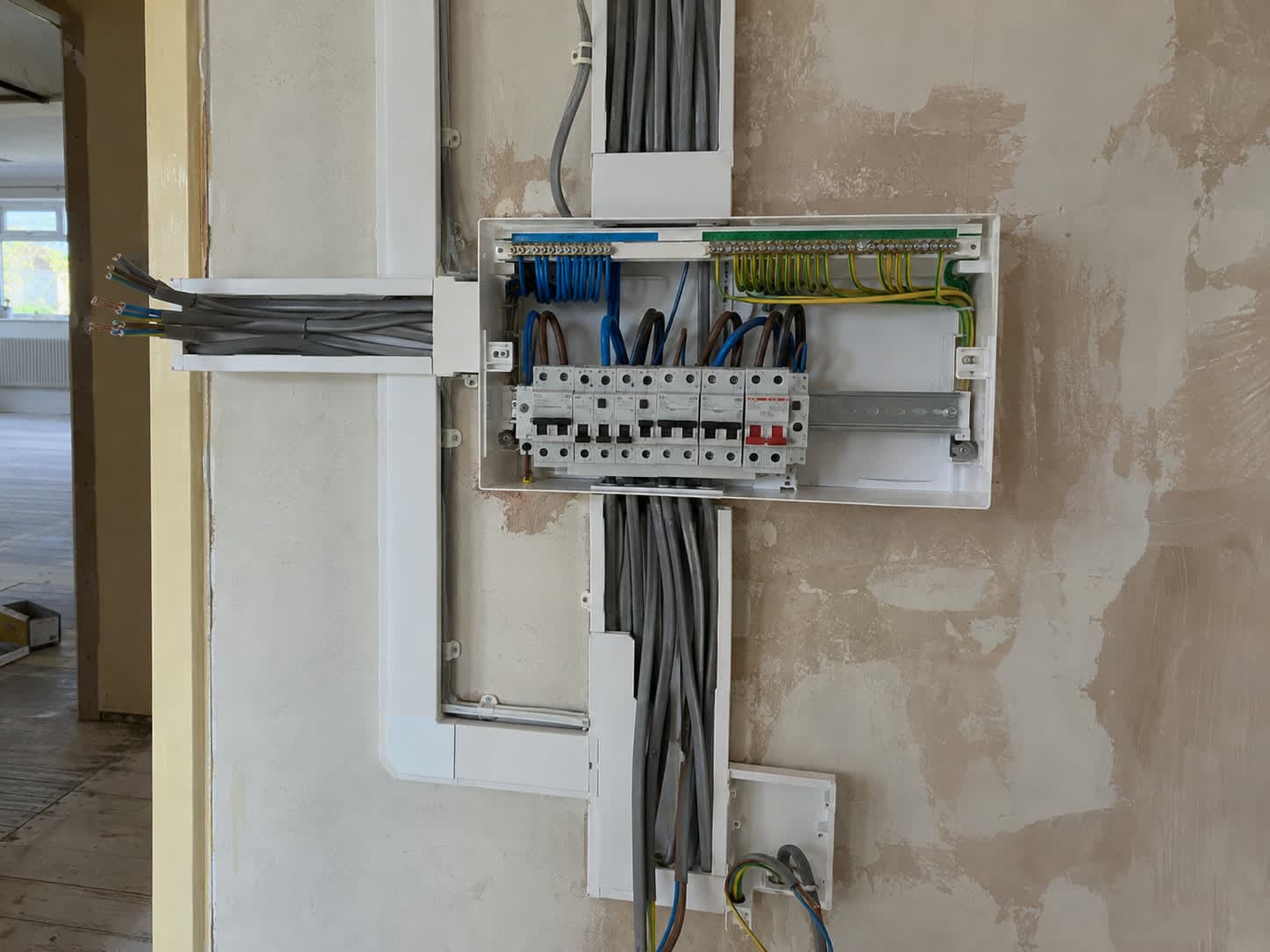 Consumer unit with neat trunked cable runs fixed to the wall, London