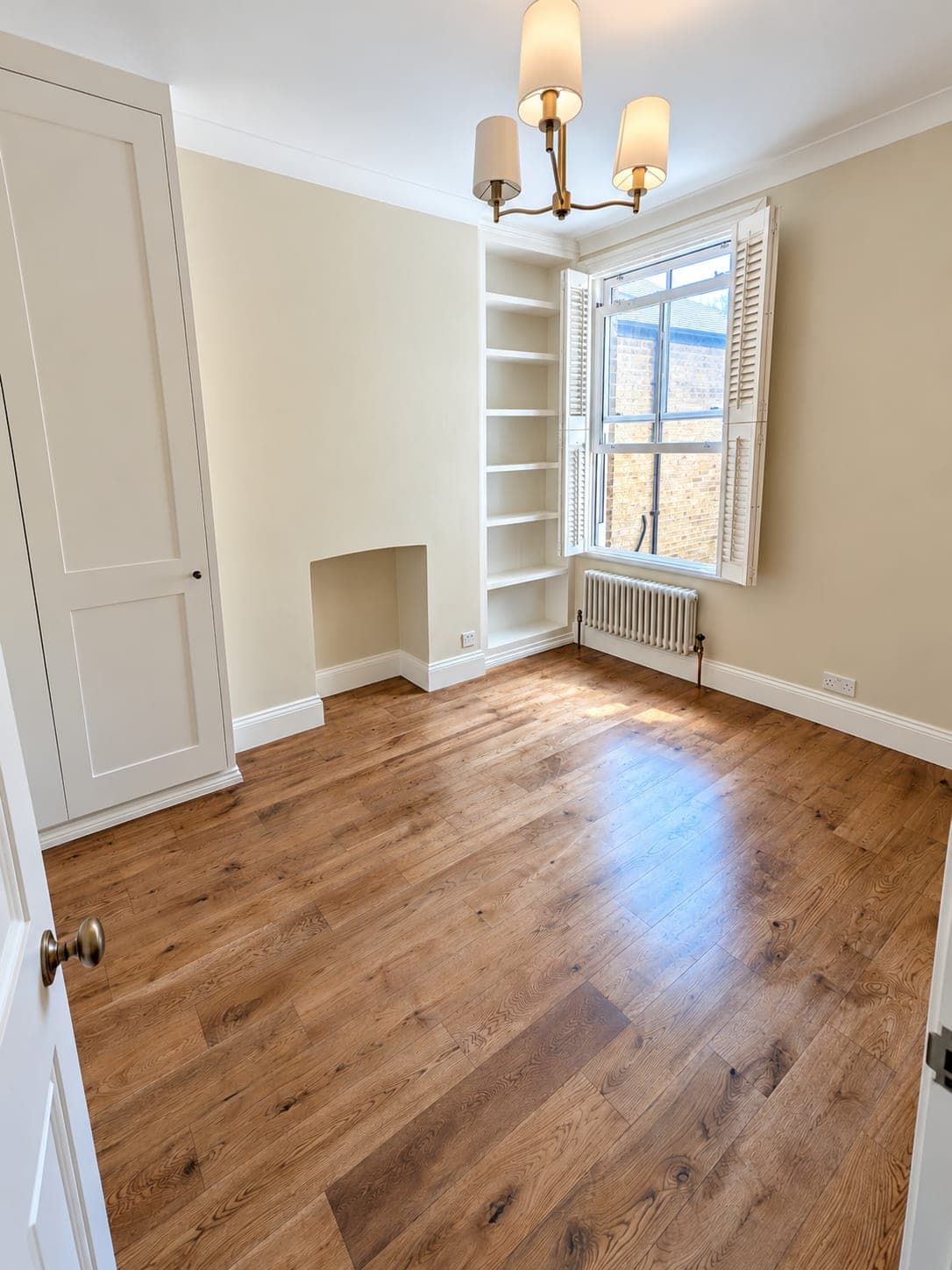 Oak flooring in a period room with cornice and alcove shelving, London
