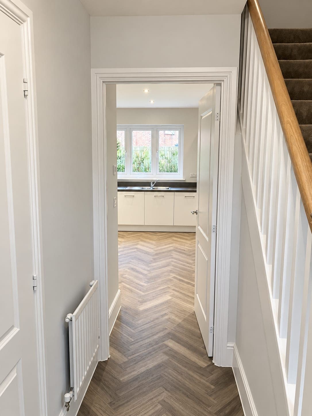 Herringbone flooring running from hallway through to the kitchen, London