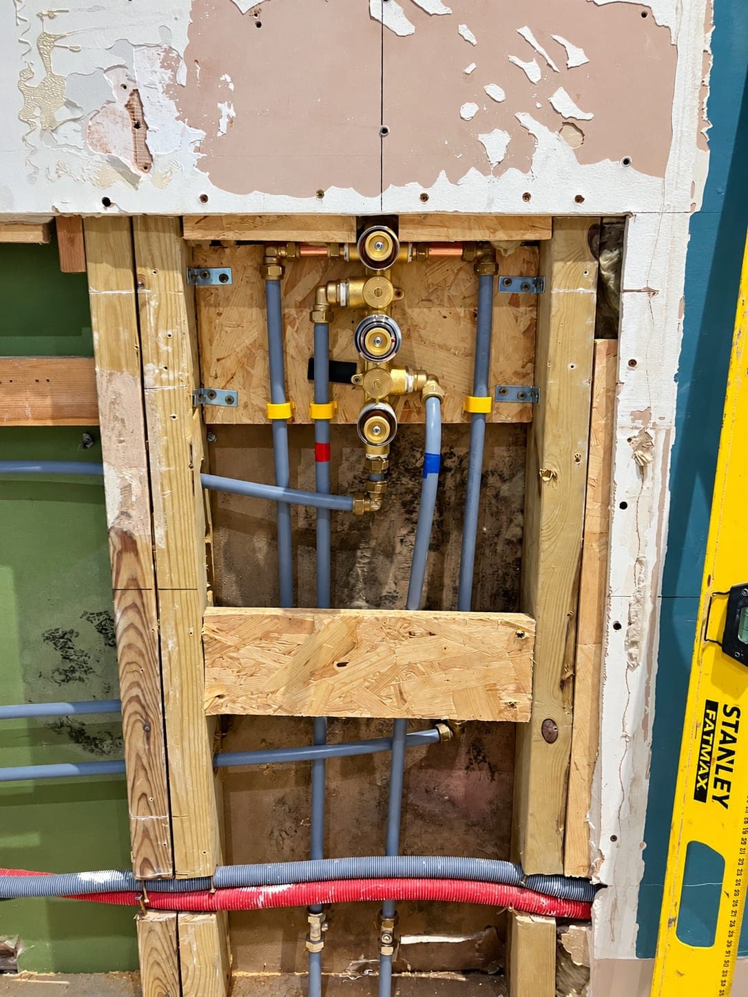Copper pipework and isolating valves fixed to a stud wall, London