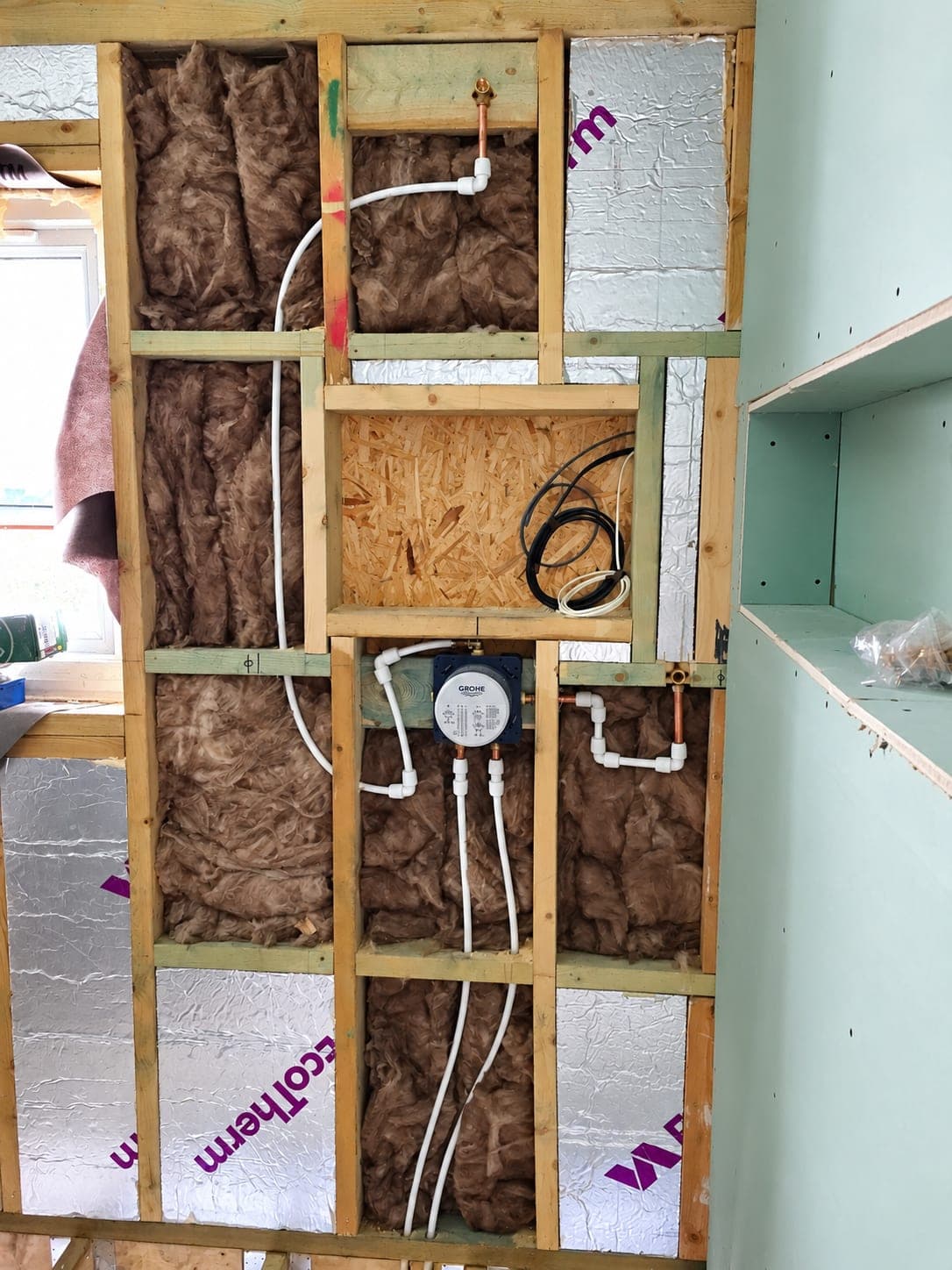 Plumbing and electrics run through an insulated partition, London