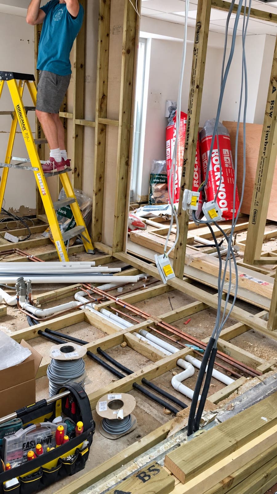 Floor lifted while new pipework is run through the joists, London