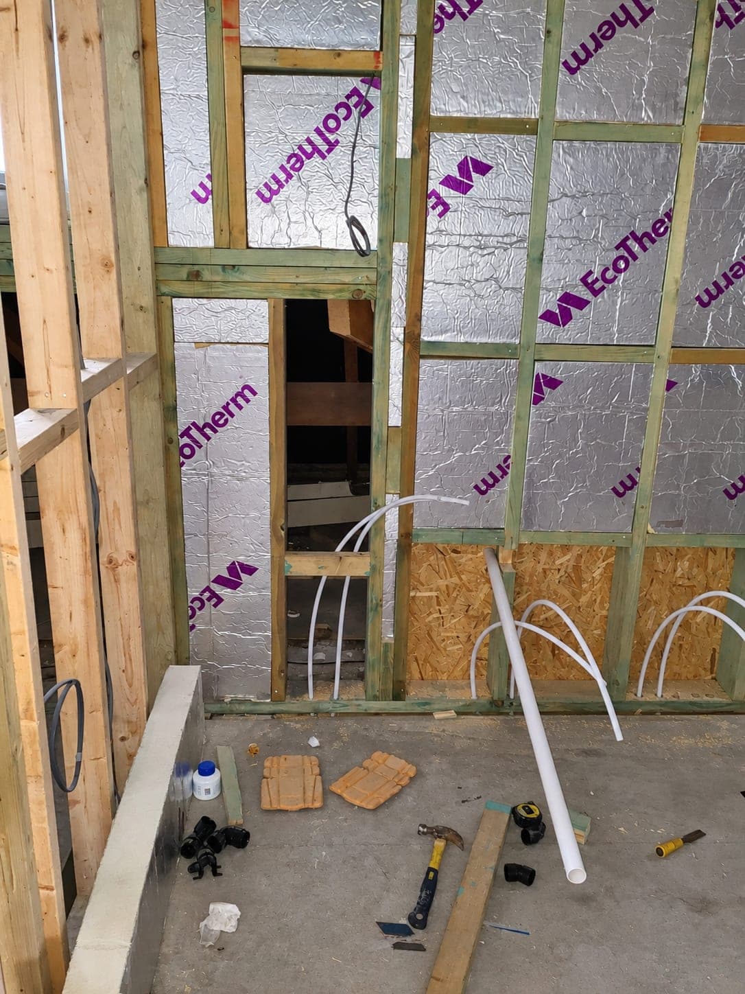 Capped pipe tails left ready for second fix in a stud wall, London