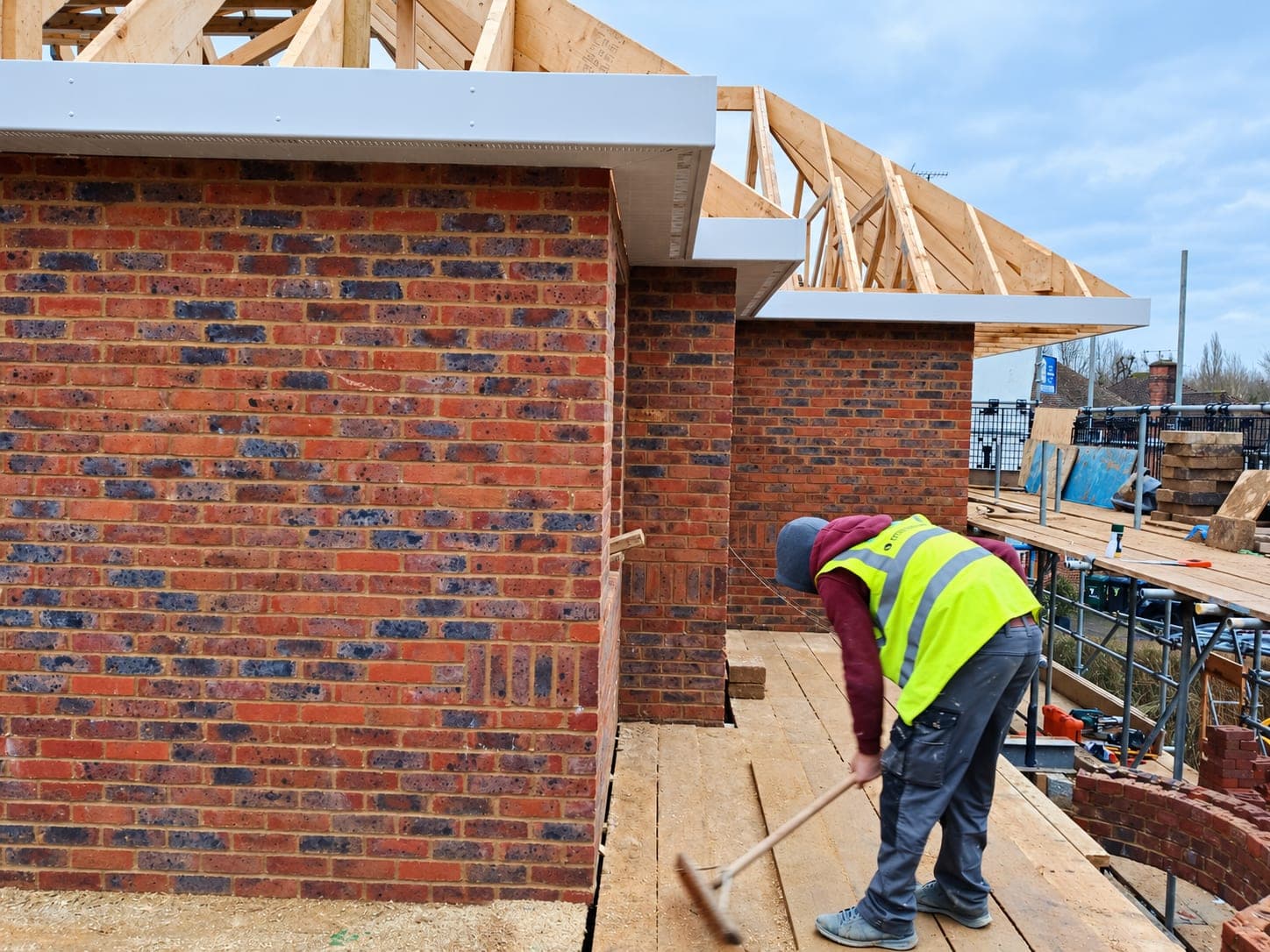 Roofer clearing down a flat roof deck before the covering goes on, London