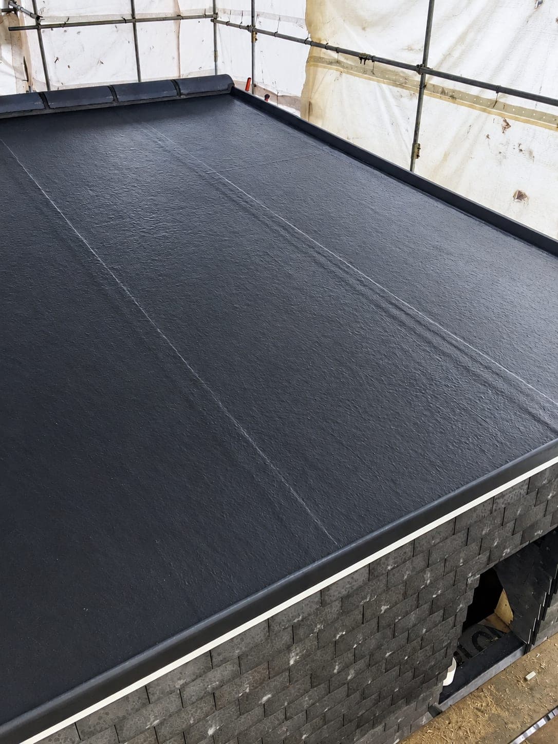 Flat roof membrane dressed up the upstand and welded at the joints, London