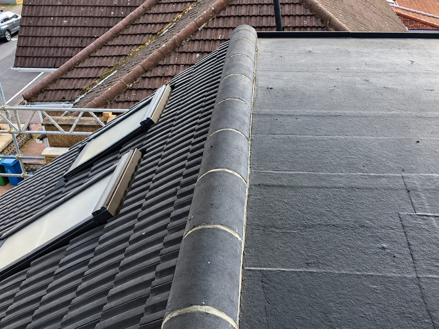 Junction between a tiled pitched roof and a flat roof section, London