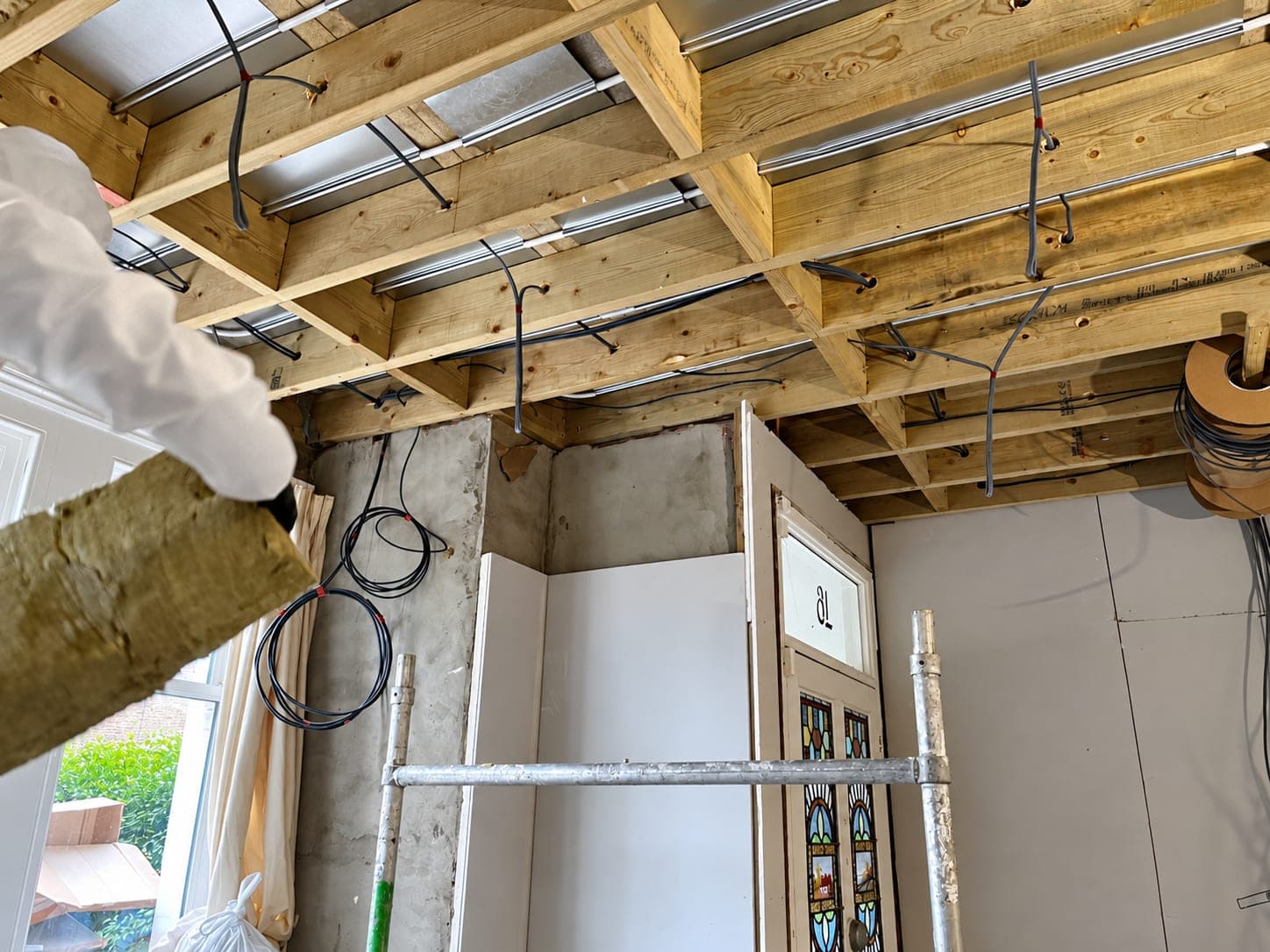Floor joists and props around a newly formed structural opening, London