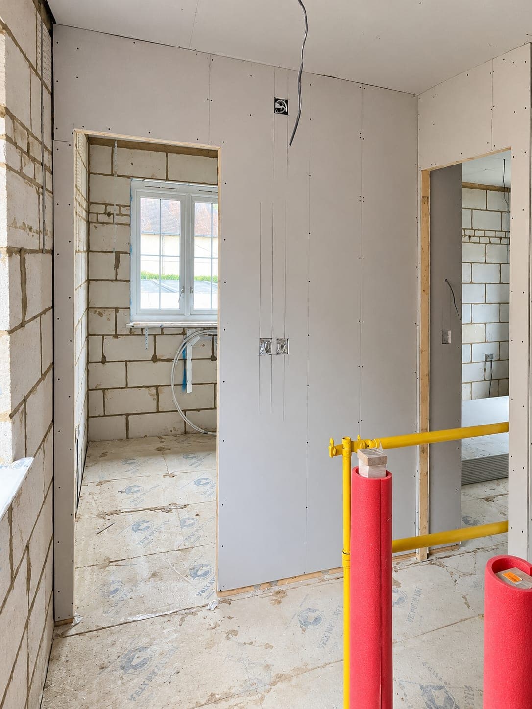 Boarded partitions with pipework and services run behind, London